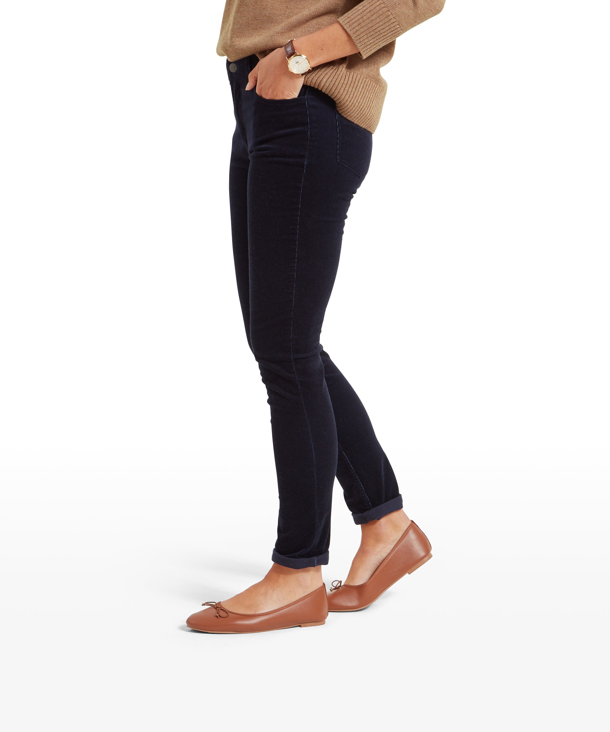 Side profile view of a woman in Schöffel Clover Cord Jean for Womens in Navy and a beige sweater. The jeans have a slim fit, and she is standing with her hands in her pockets.