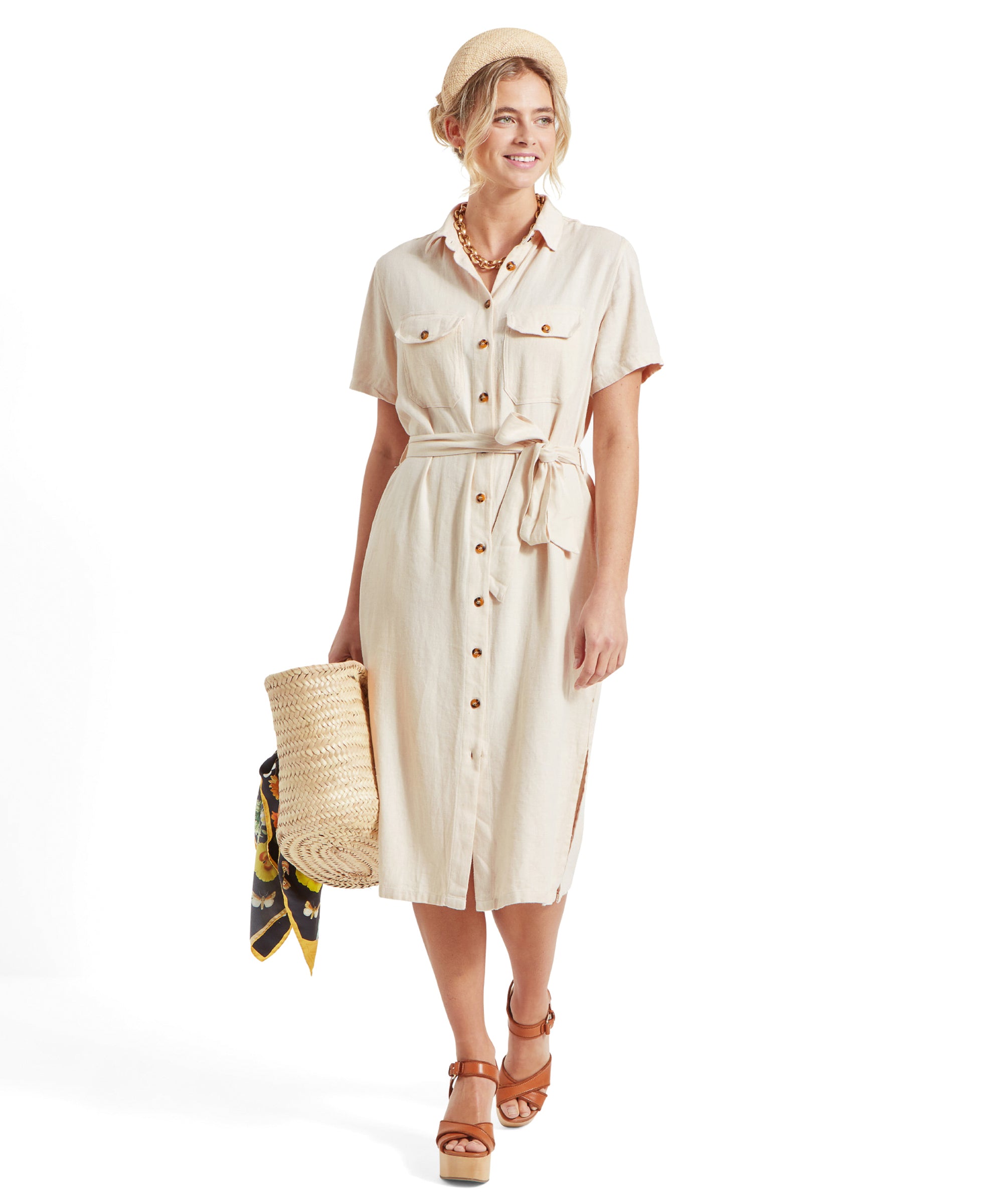 Front view of the woman holding the woven straw bag, showcasing the full length of Schöffel Daisy Linen Dress for Women in Light Brown and her accessories.