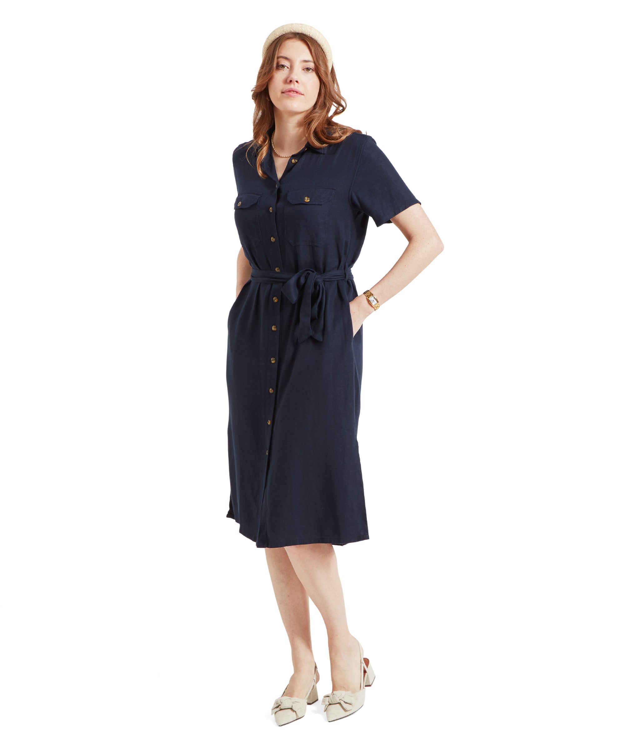 Woman wearing Schöffel Daisy Linen Dress for Women in Navy, posing with her hands in the pockets, showing the dress's side profile.