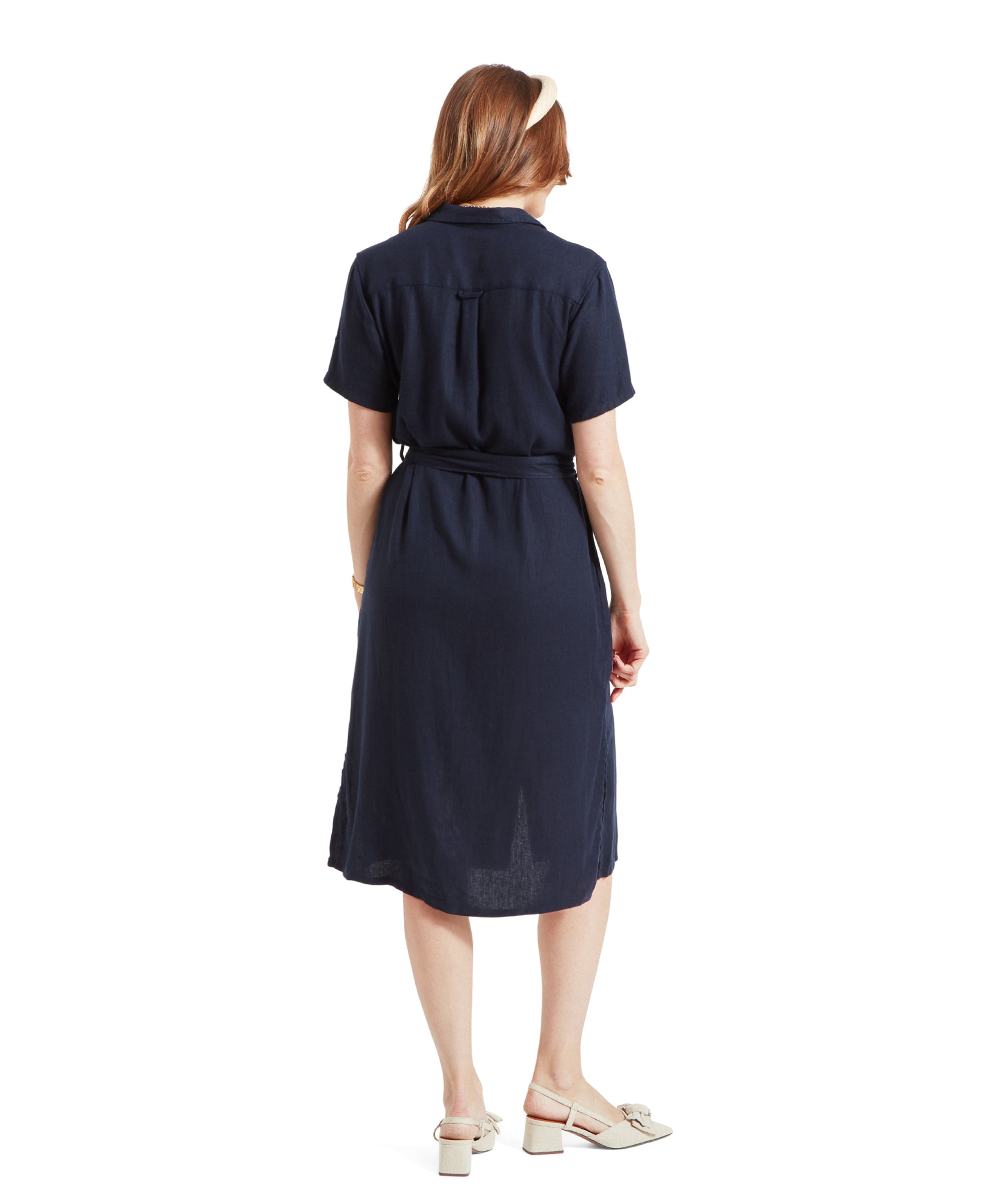 Rear view of a woman in Schöffel Daisy Linen Dress for Women in Navy, highlighting the dress's back design and length.