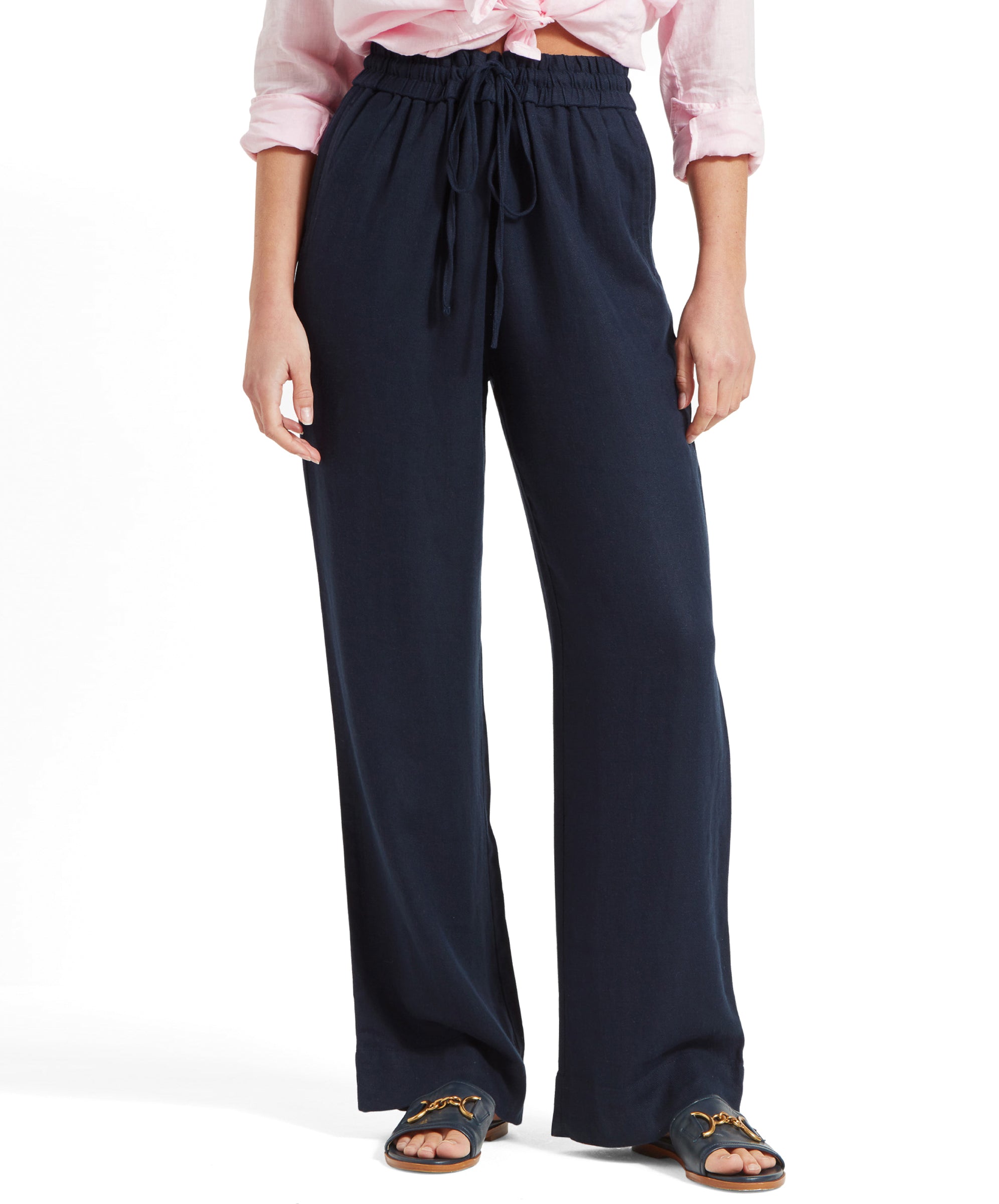 Front view of a woman wearing Schöffel Women's Daphne Trousers in navy, paired with a pink shirt tied at the waist.