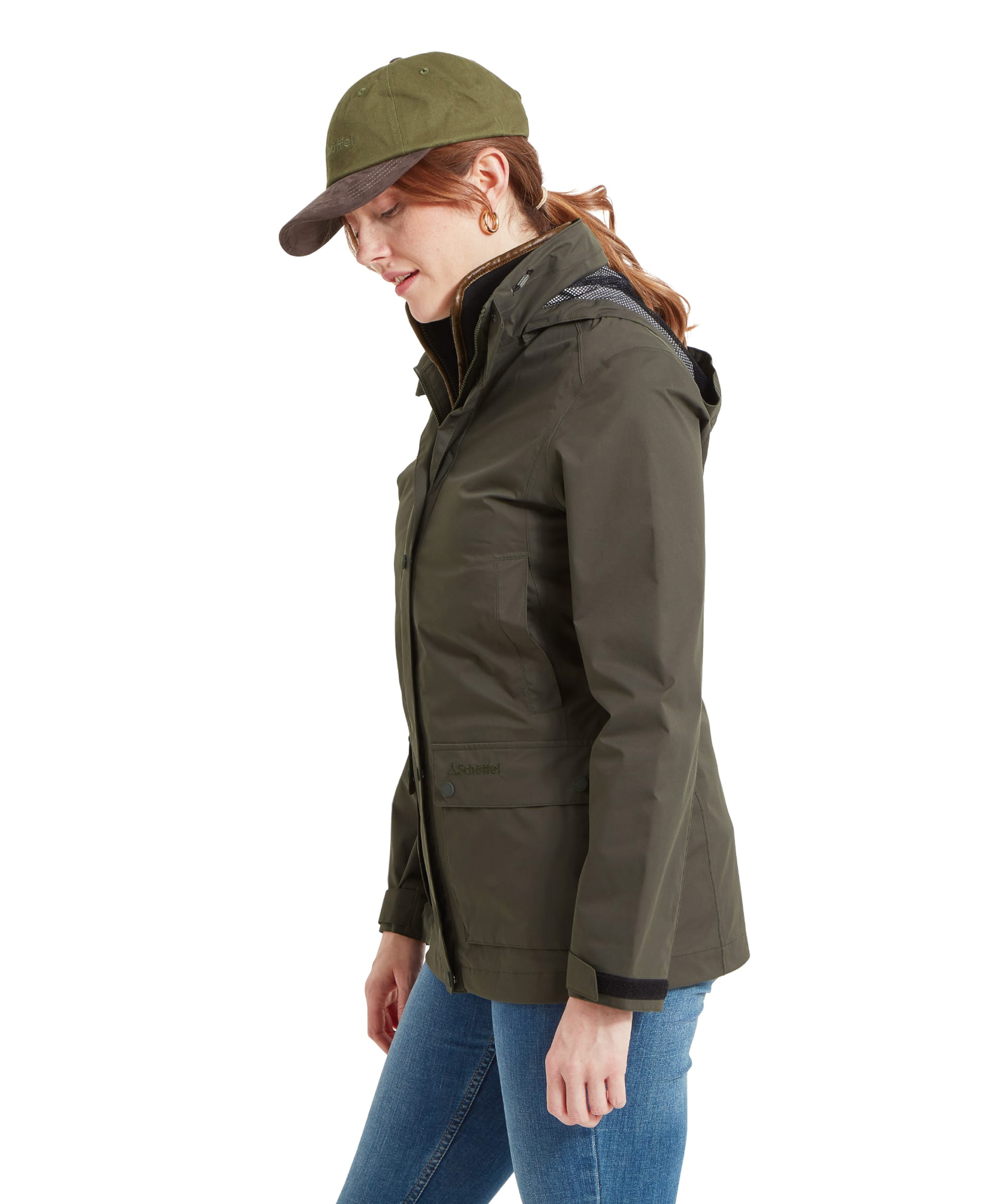 Side view of a woman wearing an Schöffel Edith Jacket for Women in Green, showcasing the fitted design and functional pockets. The jacket has a slightly extended back for added coverage.