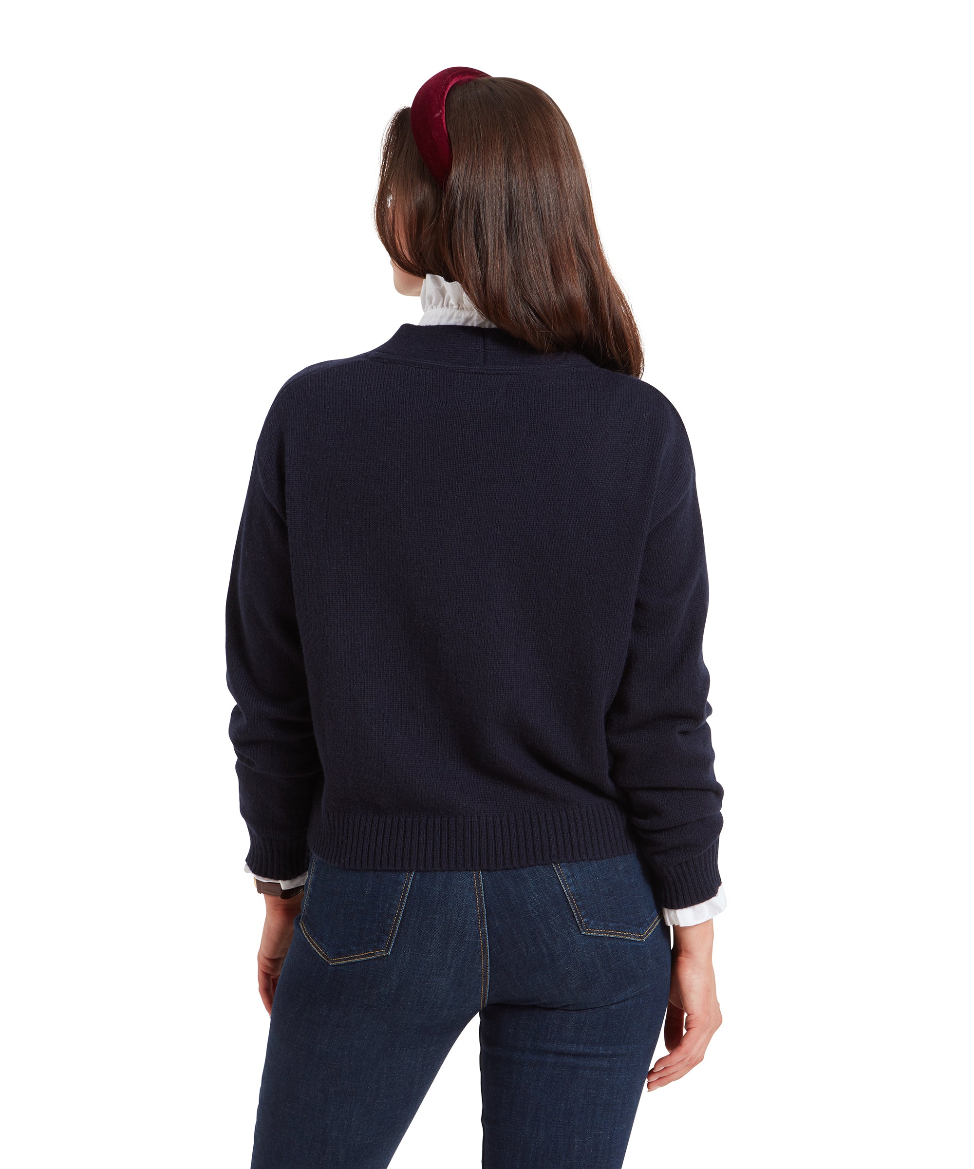 Rear view of the woman wearing the Schöffel Filey Cardigan for Women in Navy, showing the back details of the garment, with her hair partly obscured by the red headband.