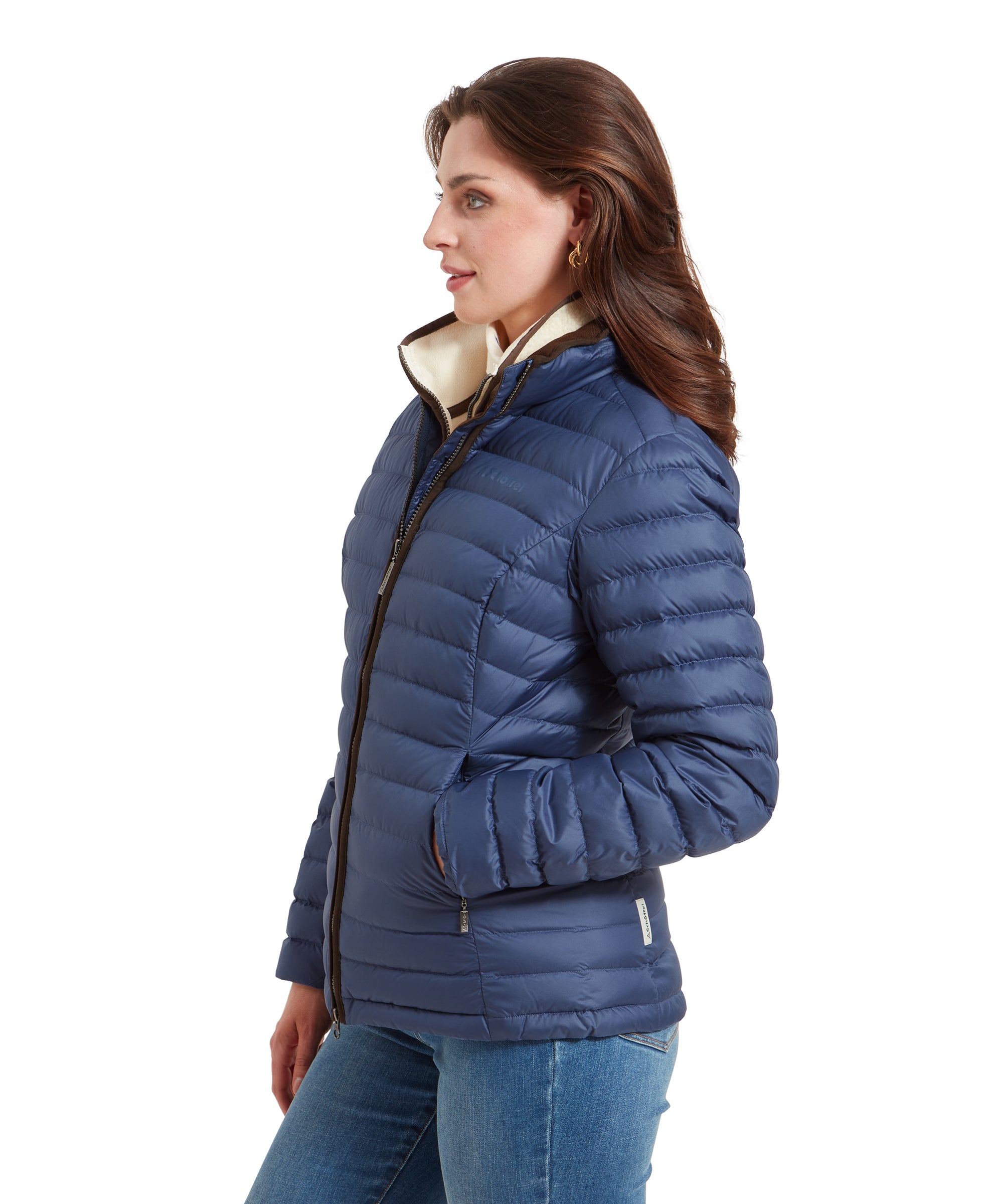 Side profile of a woman wearing a Schöffel Hambleton Down Jacket for Women in Blue. She is looking straight ahead with her hands in her pockets.