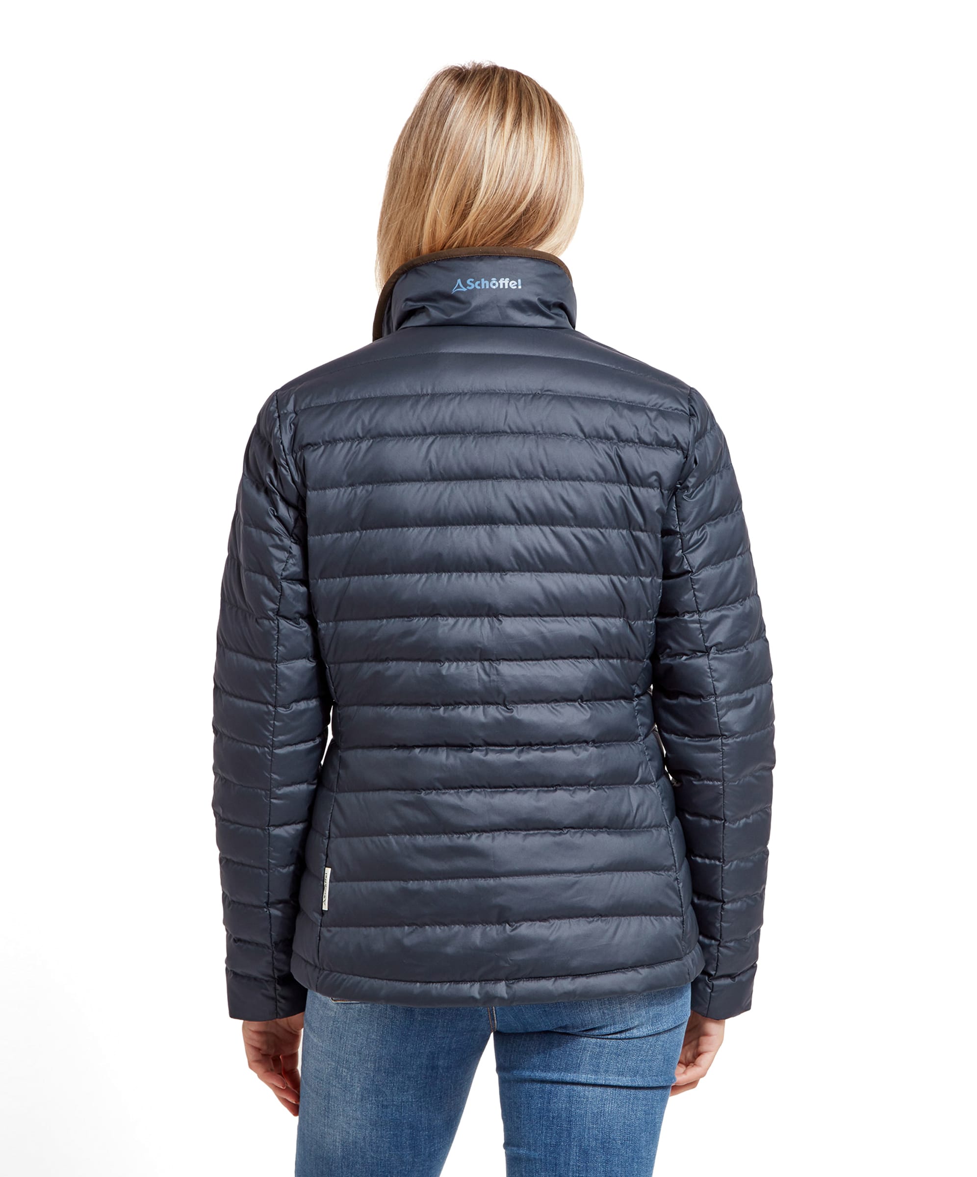 Rear view of the woman wearing the Schöffel Hambleton Down Jacket for Women in Navy, showing the back design and the brand logo on the collar.