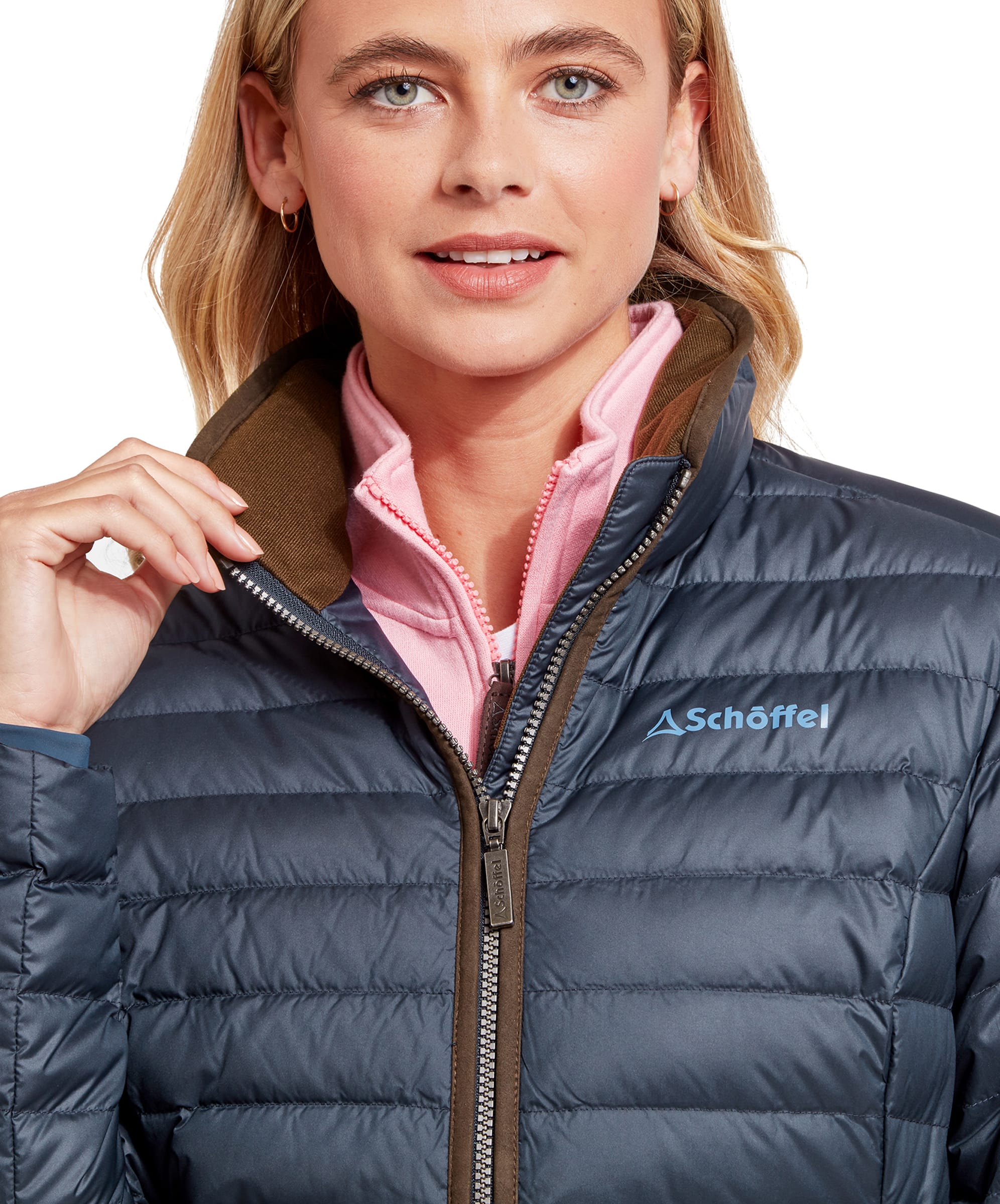 Close-up of the woman adjusting the collar of her Schöffel Hambleton Down Jacket for Women in Navy, highlighting the brown inner collar and the logo on the chest.