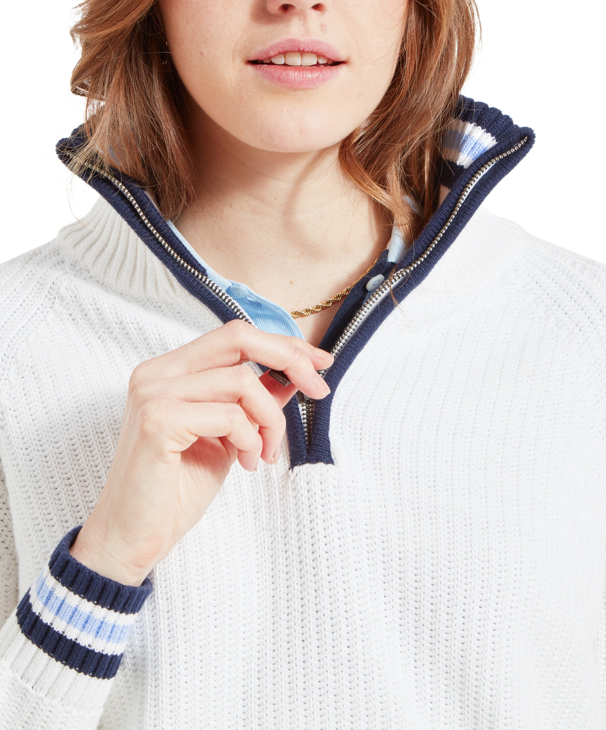 A close-up of the woman’s face and upper chest, highlighting the collar and zipper of the Schöffel Havelet Bay 1/4 Zip Jumper for Women in Blue. She is wearing a light blue shirt underneath and a delicate gold necklace