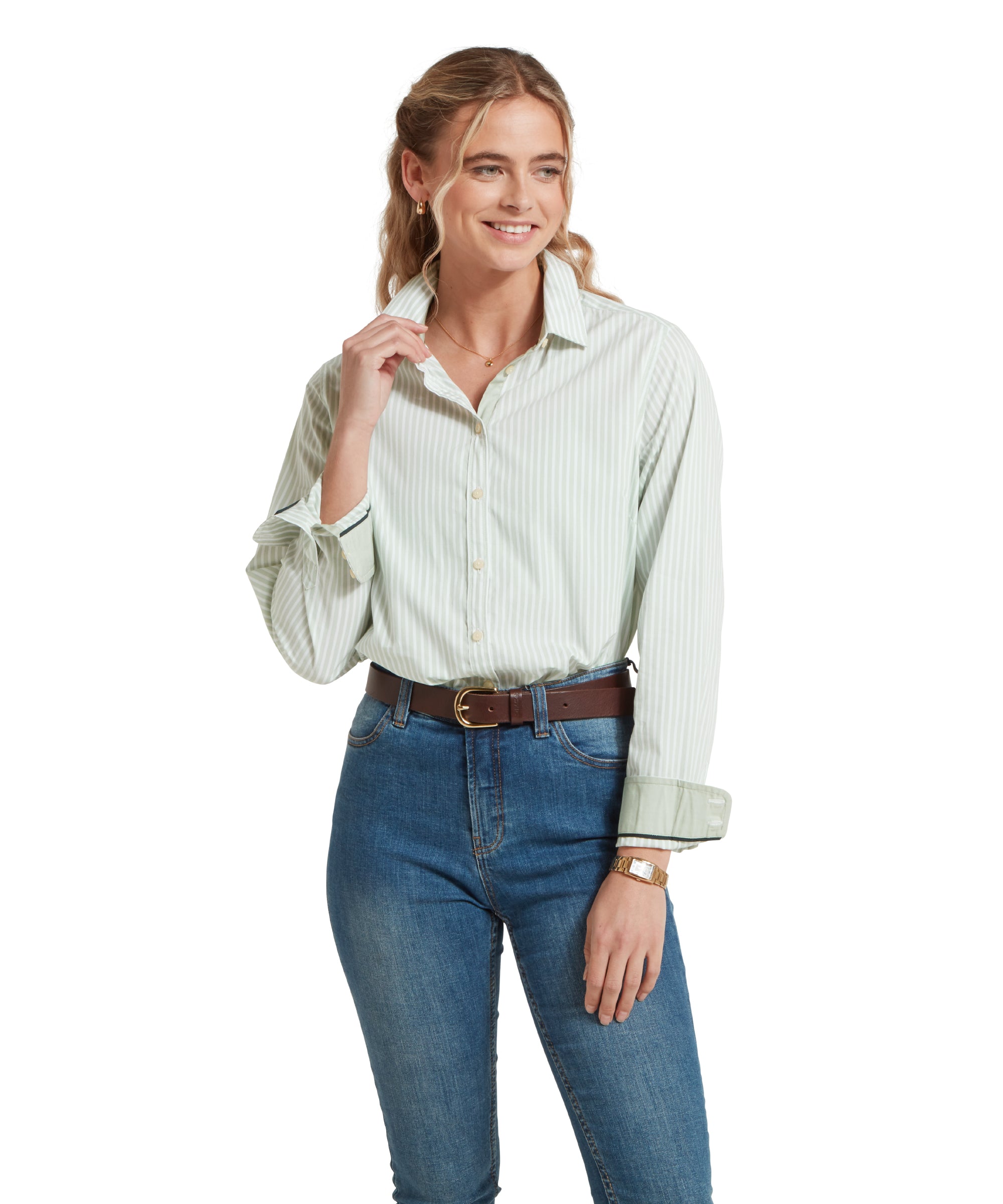 Close-up of a female model wearing a green and white striped Schöffel shirt, paired with mid denim jeans and a tan leather belt.