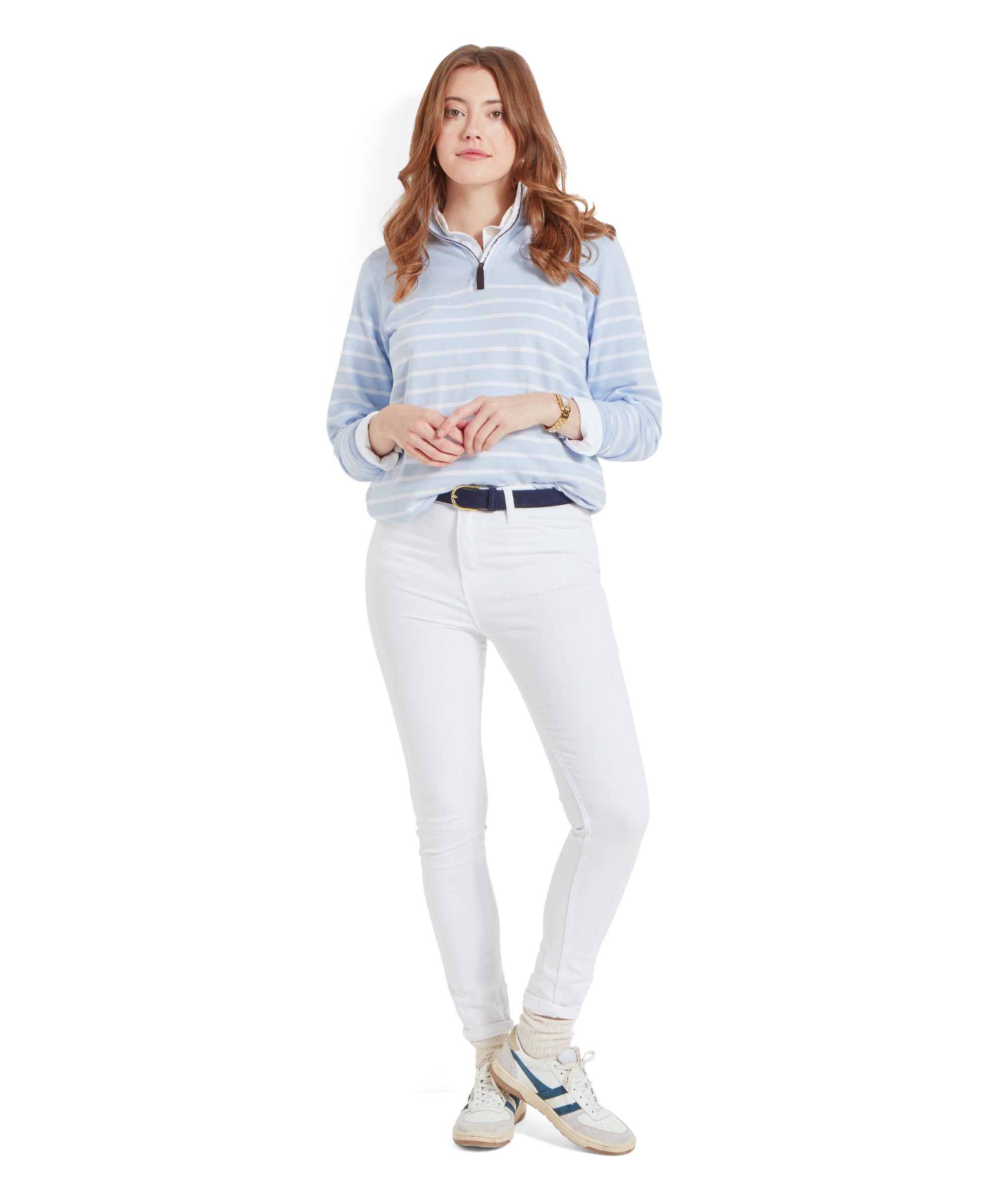 A full-body image of a woman in a Schöffel Hope Cove Sweatshirt for Women in Blue, white jeans, and white sneakers, standing with hands together, looking at the camera, with a white background.