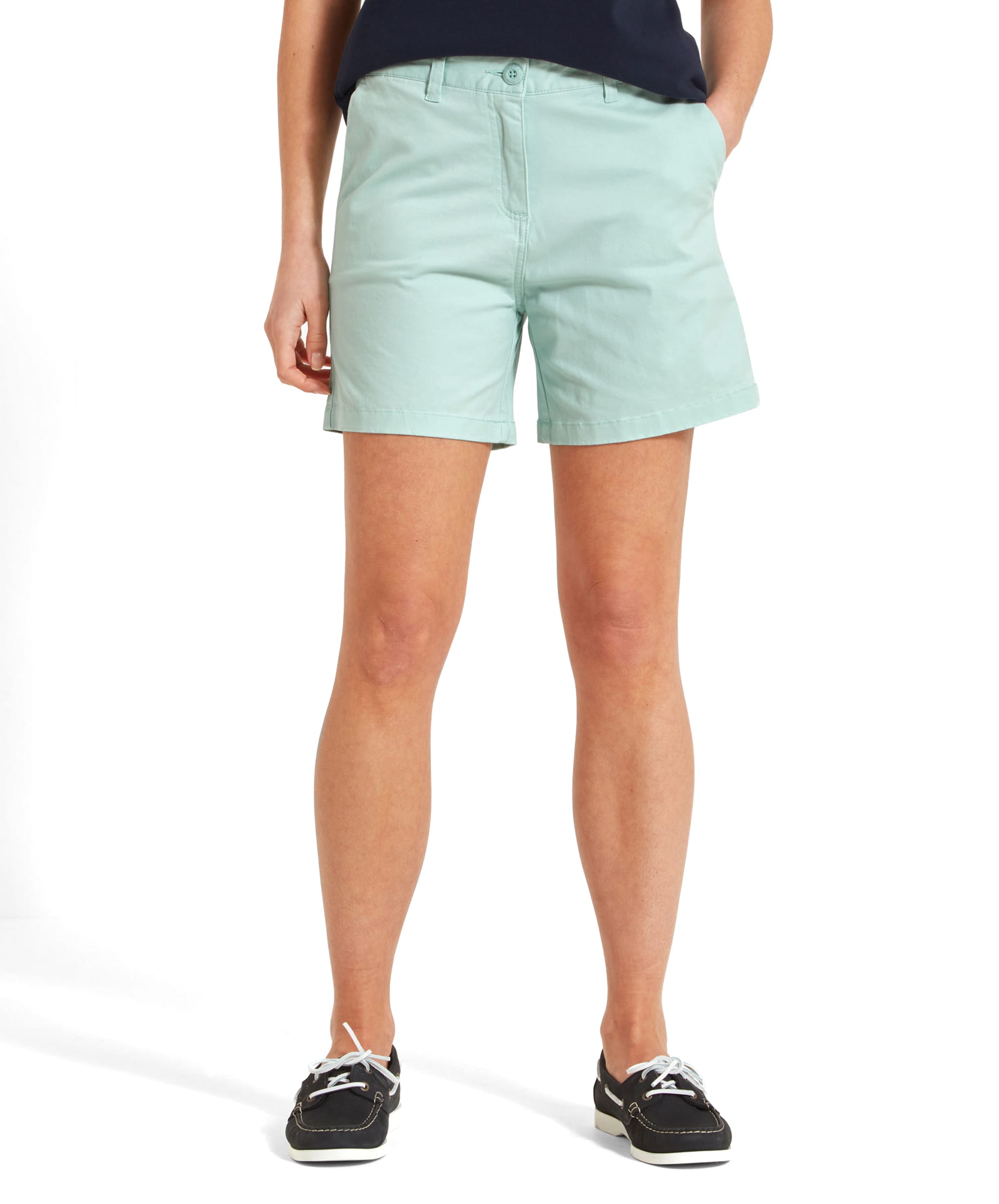 A close-up front view of a woman wearing Schöffel Iris Shorts for Womens in Green, showing the waistband, front button, and side pockets.