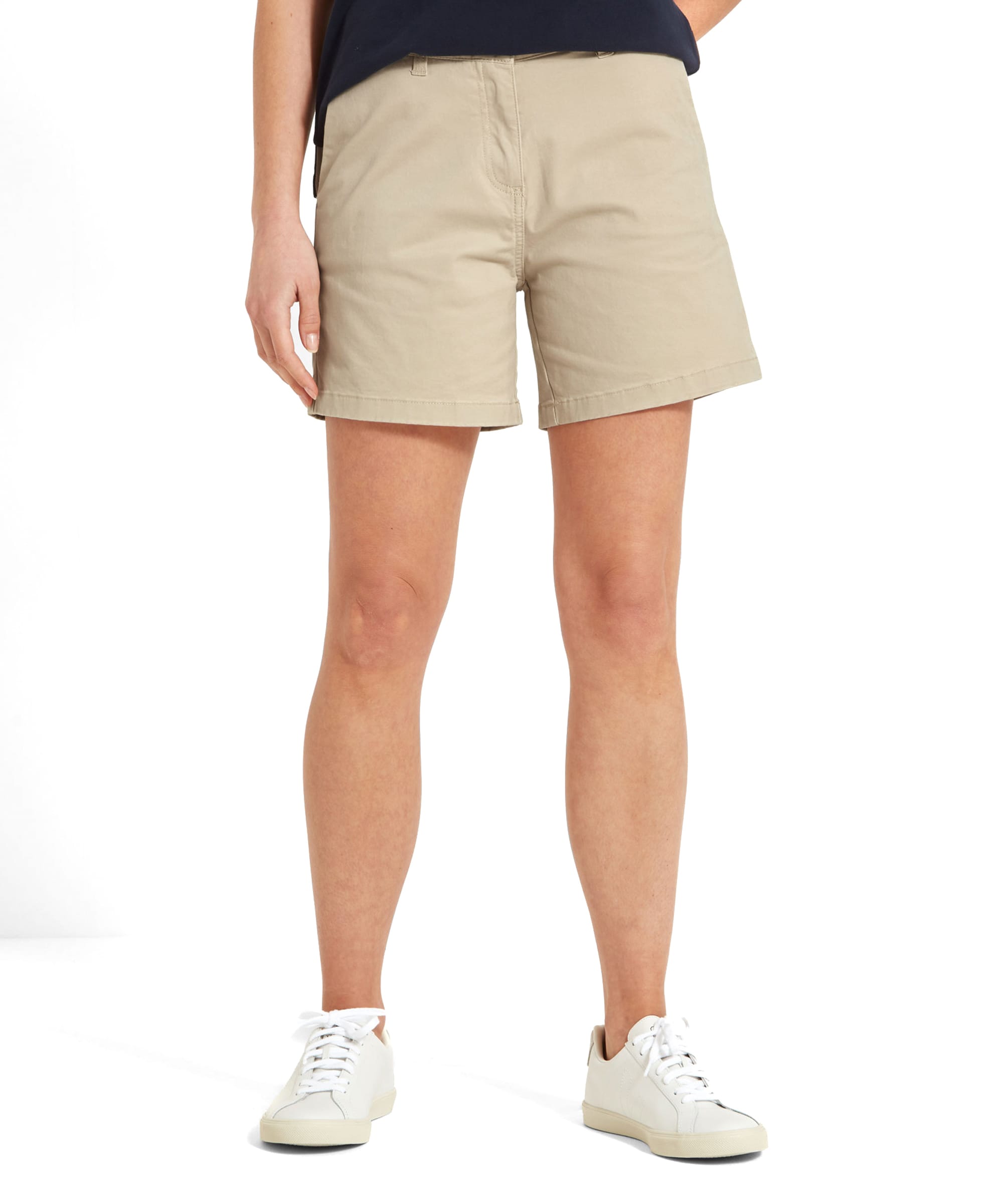 Front view of a person wearing Schöffel Iris Shorts for Womens in Light Brown with a navy blue top and white trainers.