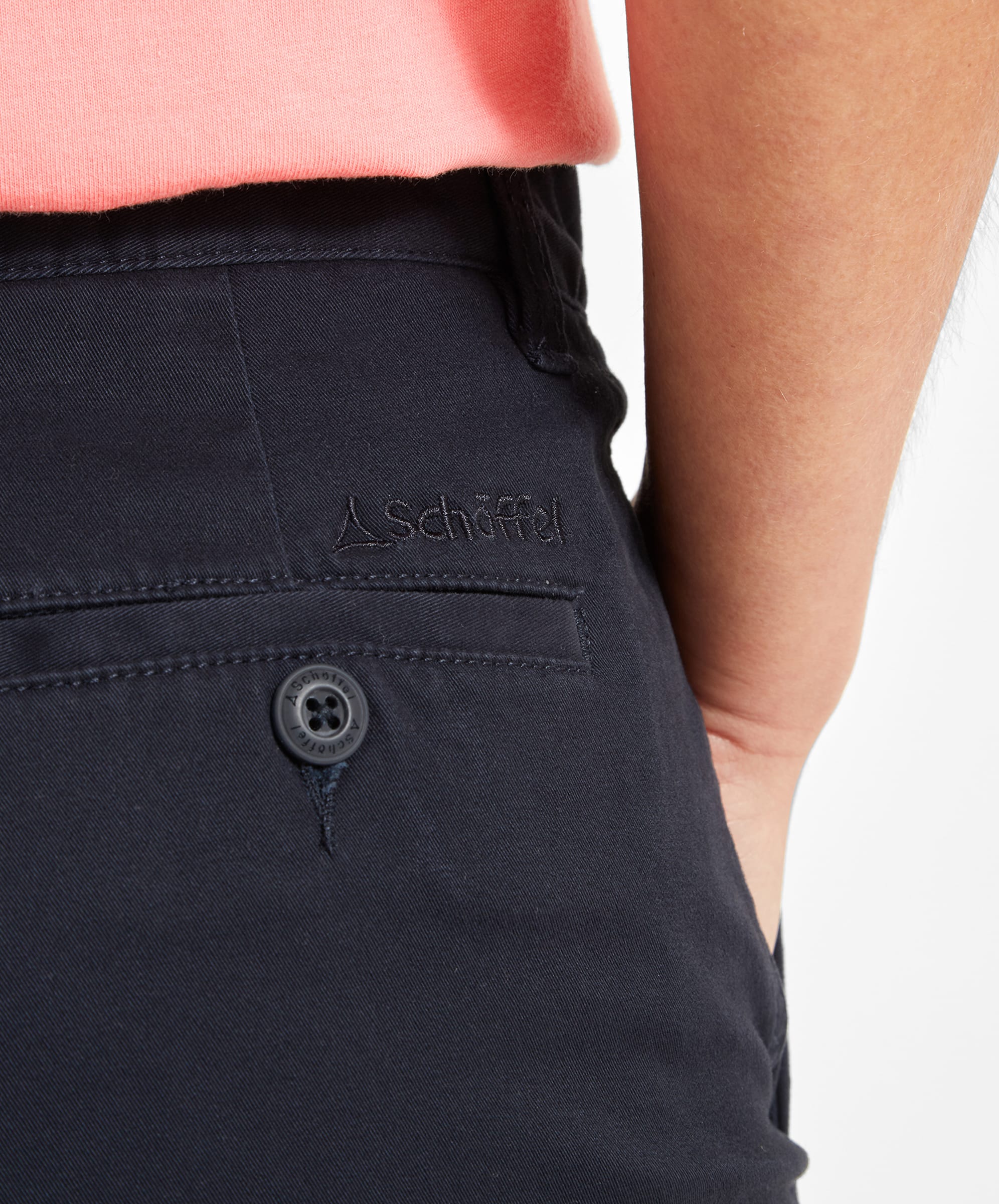 A close-up of the back pocket of the Schöffel Iris Shorts for Womens in Navy, showing the detailed stitching and the embroidered Schoffel logo in navy thread on the waistband.