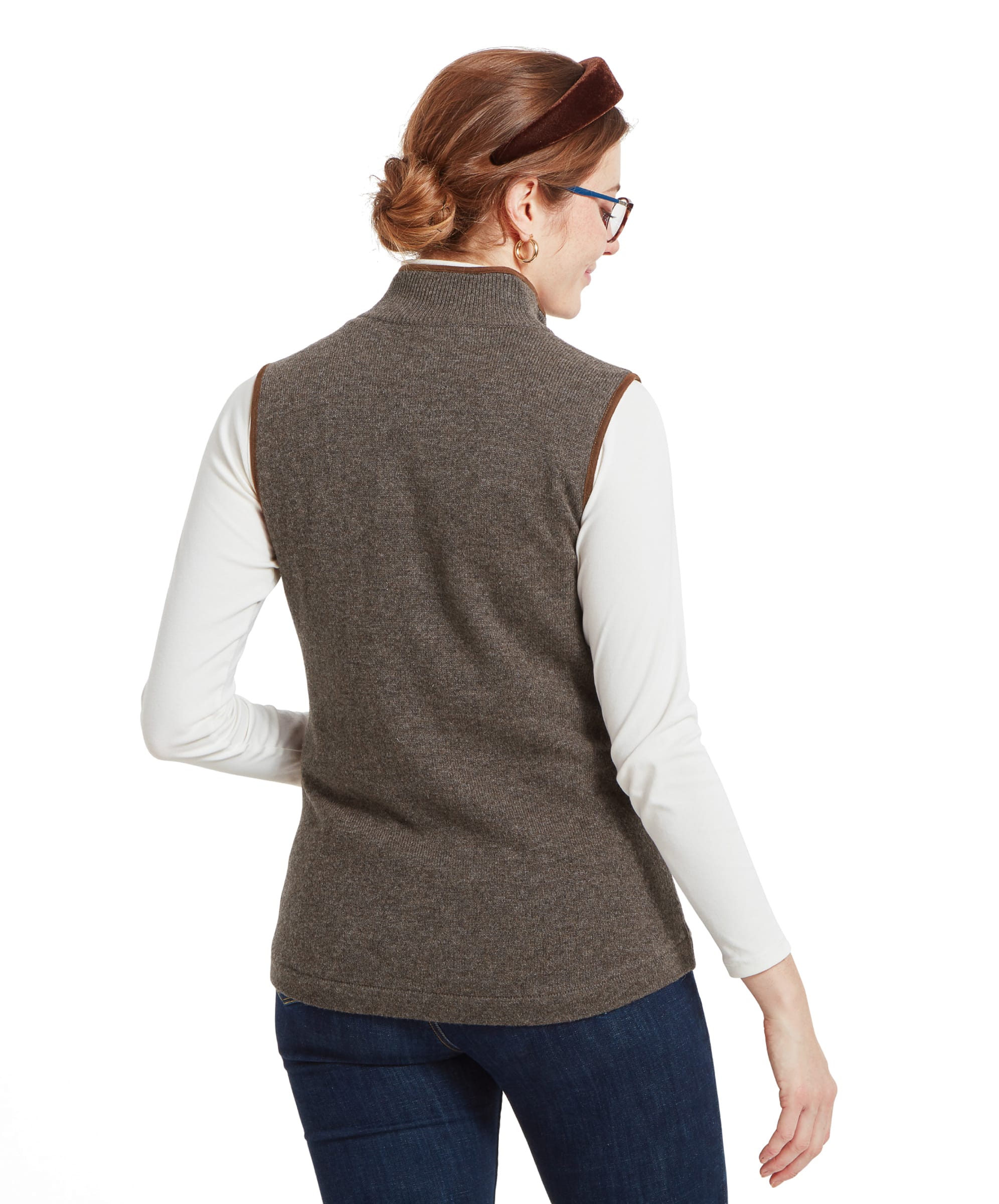 Back view of a woman wearing a Schöffel Women's Lambswool Aerobloc Gilet for Womens in Brown over a white turtleneck. The gilet has a high collar.