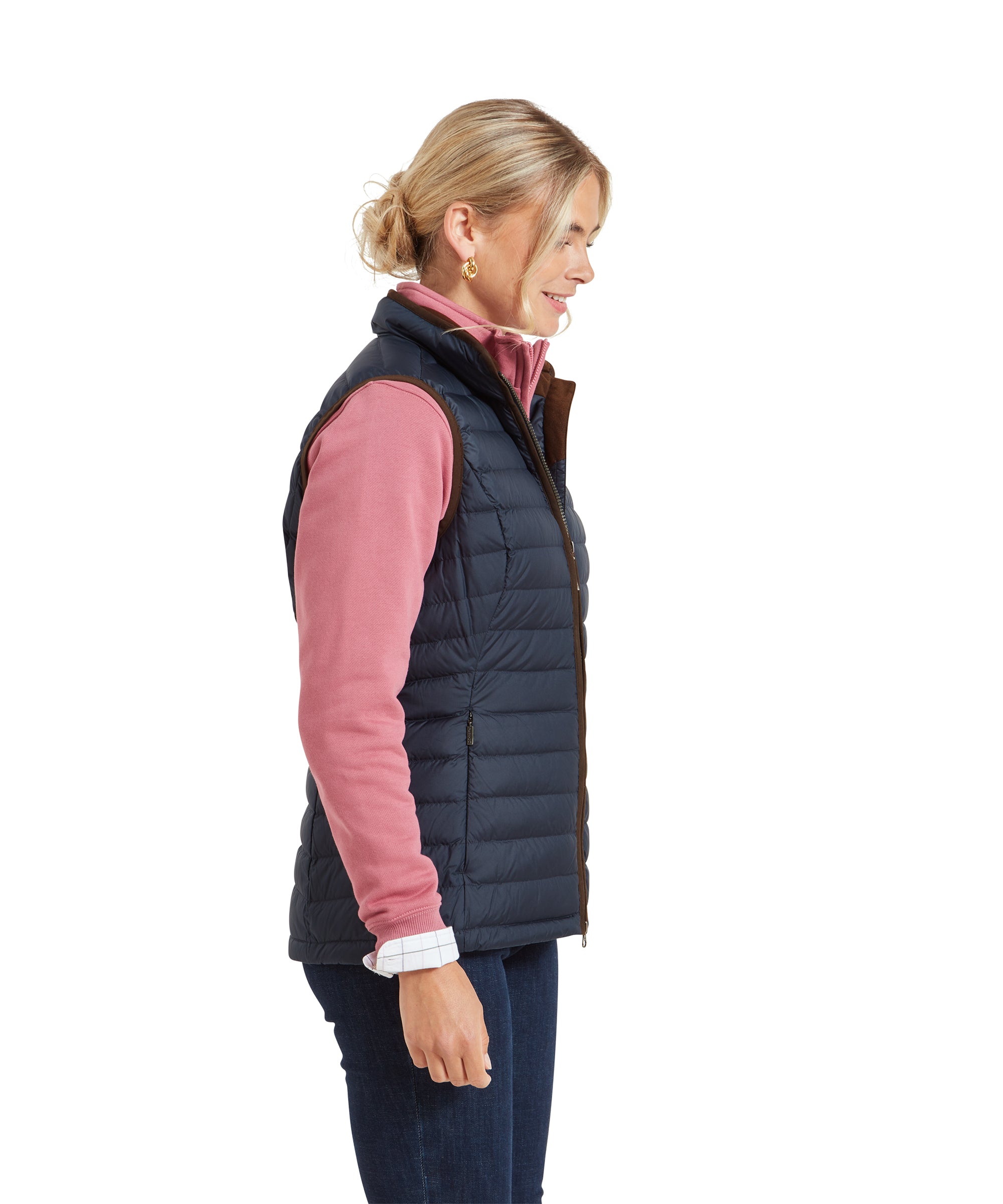 A side profile of the woman wearing the Schöffel Launde Down Gilet for Women in Navy, highlighting the slim fit and quilted texture of the gilet.