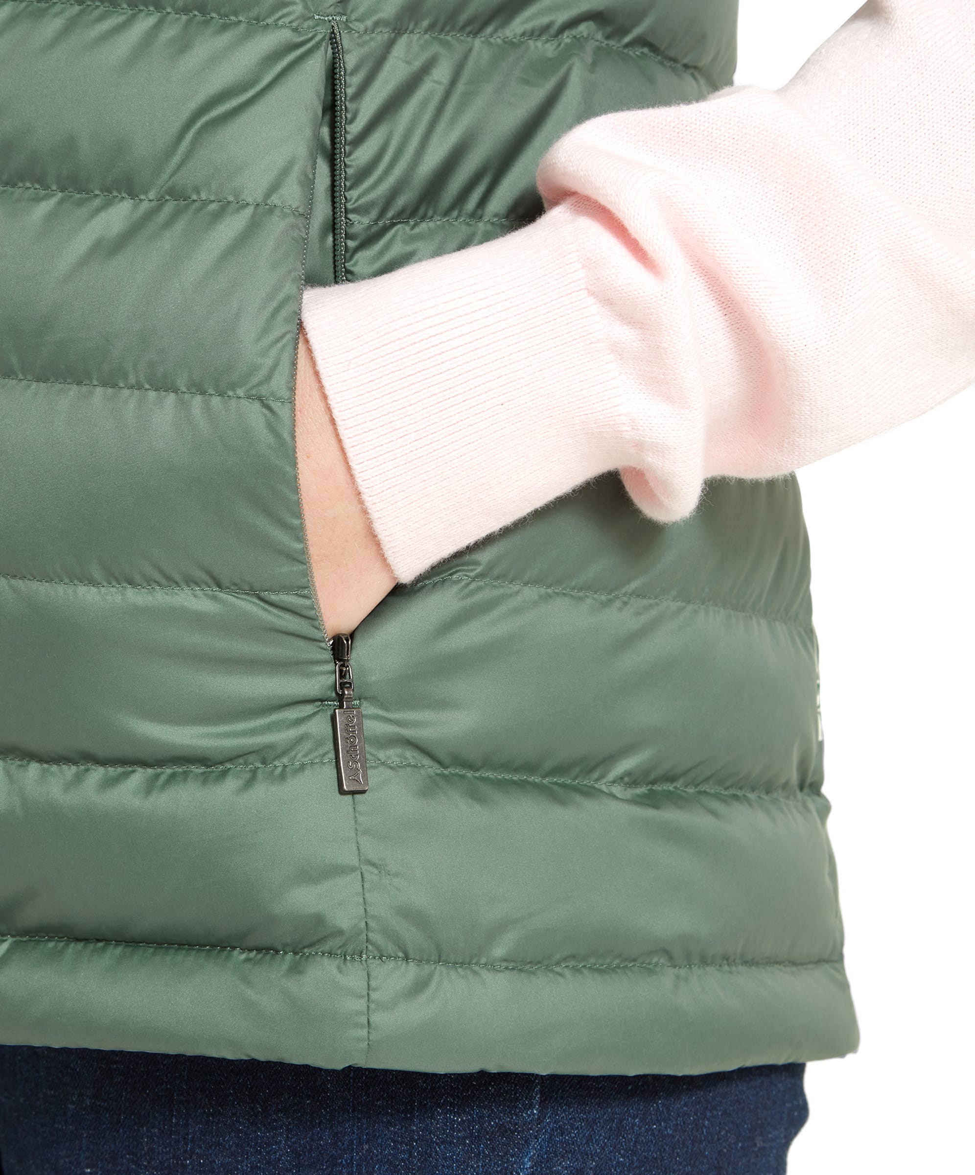 A close-up of the Schöffel Launde Down Gilet for Women in Green highlighting the neat invisible zip design and finished with a metal Schöffel branded zip pull.