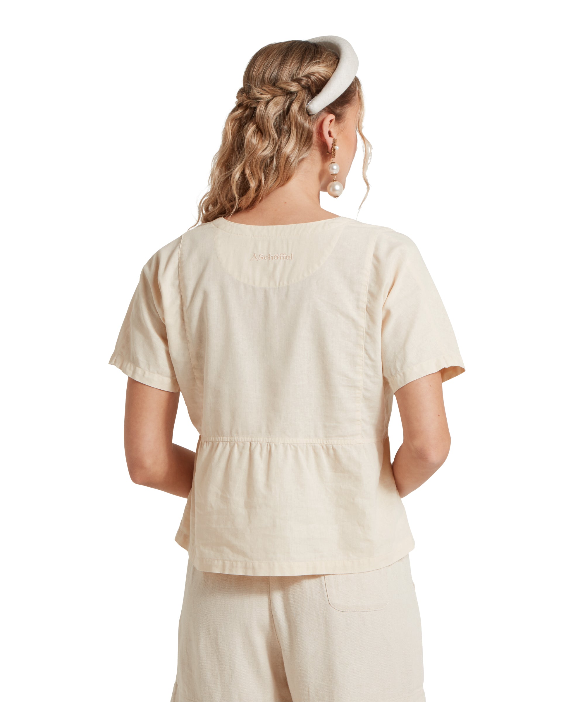 Back image of a female model wearing a v-neck beige linen Schöffel top, beige linen shorts.