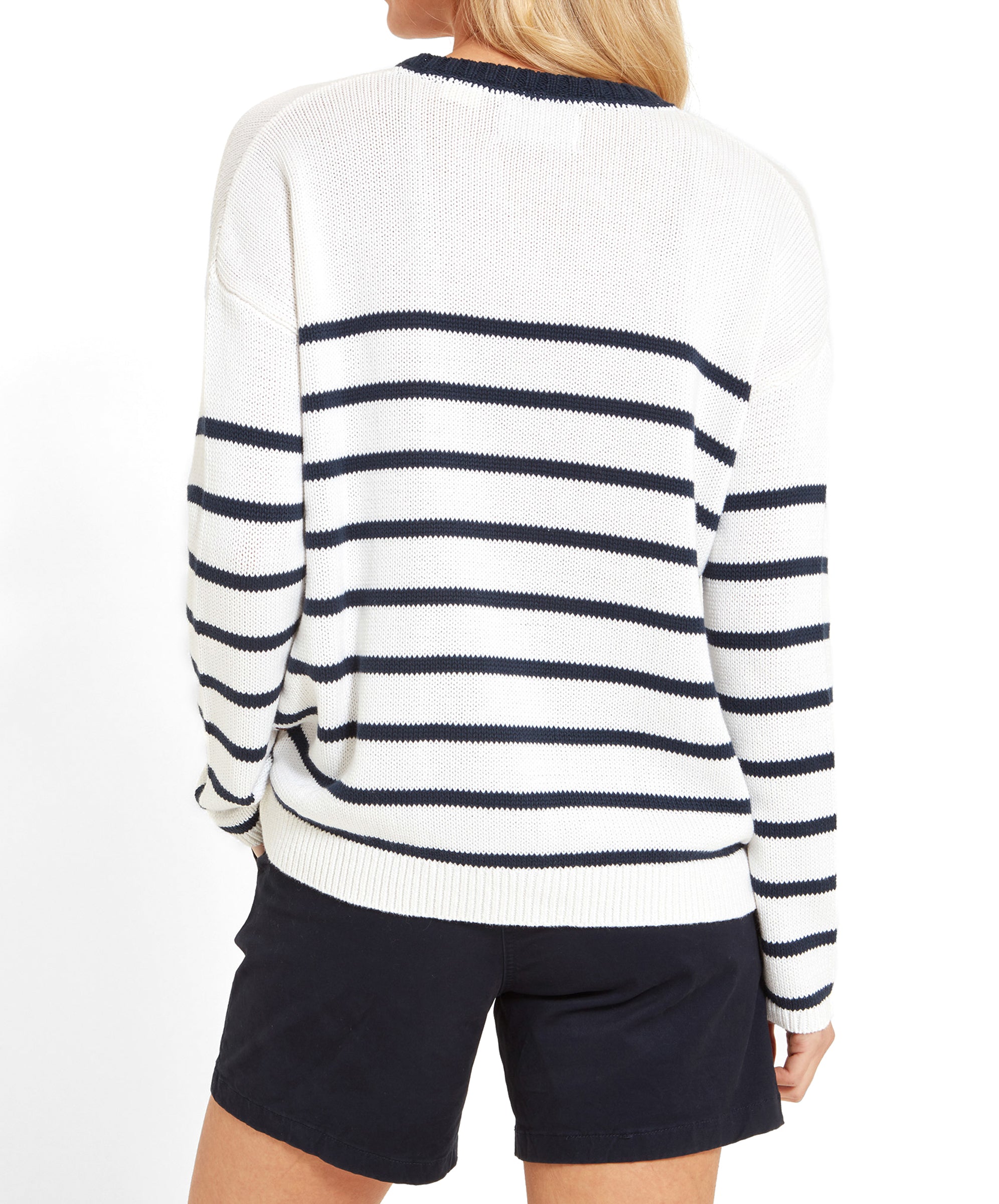 The back view of the white jumper with navy stripes, showing the full striped pattern, worn by a woman with blonde hair.