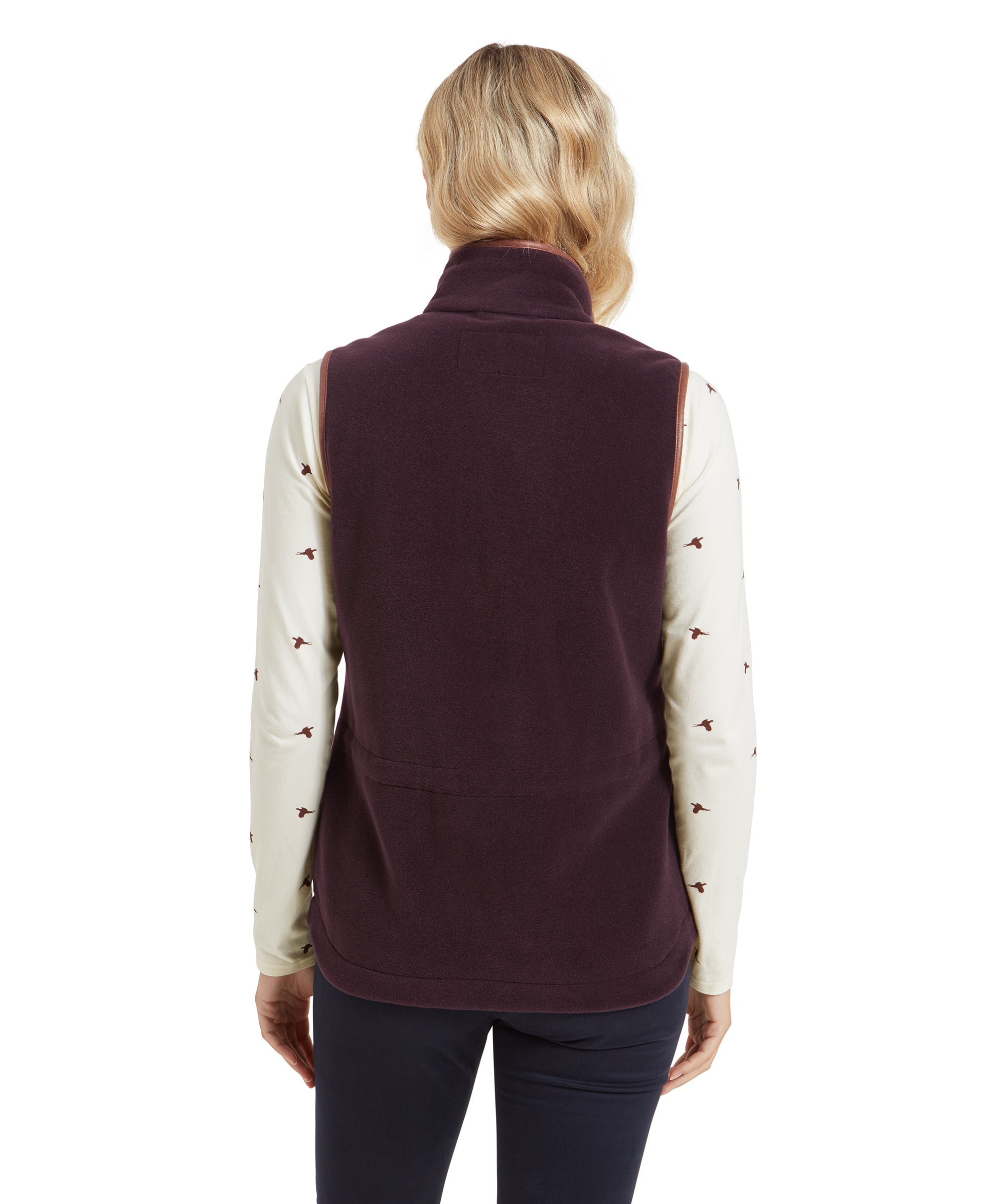 The back view of the Schöffel Lyndon Fleece Gilet for Women in Brown shows the straight cut and the slightly curved hem at the back. The woman’s hair falls naturally, and the gilet's high collar is visible.