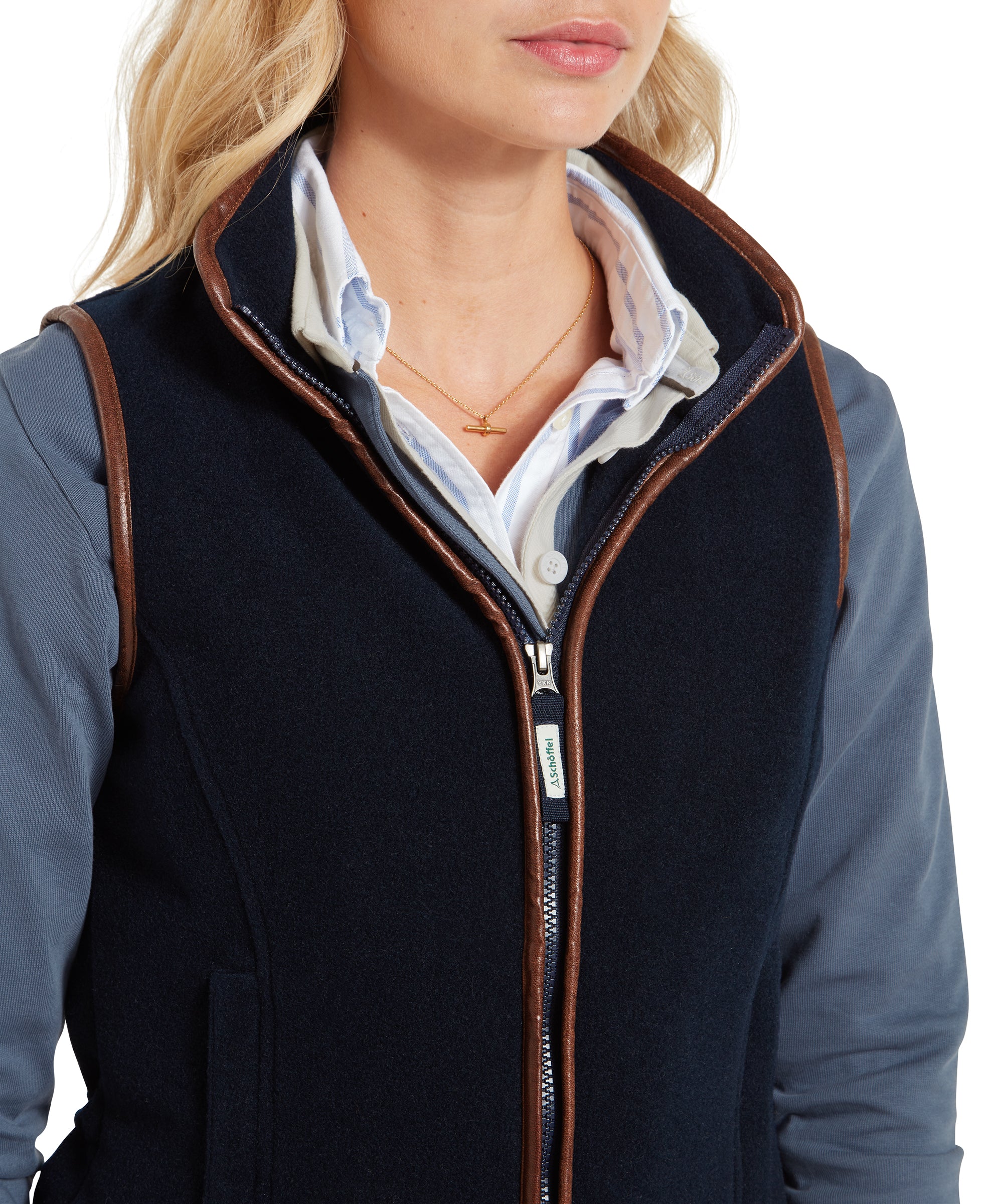 Another close-up focuses on the collar and zipper of the Schöffel Lyndon Fleece Gilet for Women in Navy, displaying the attention to detail in the brown trim and zipper pull, as well as the layering of the shirt underneath.