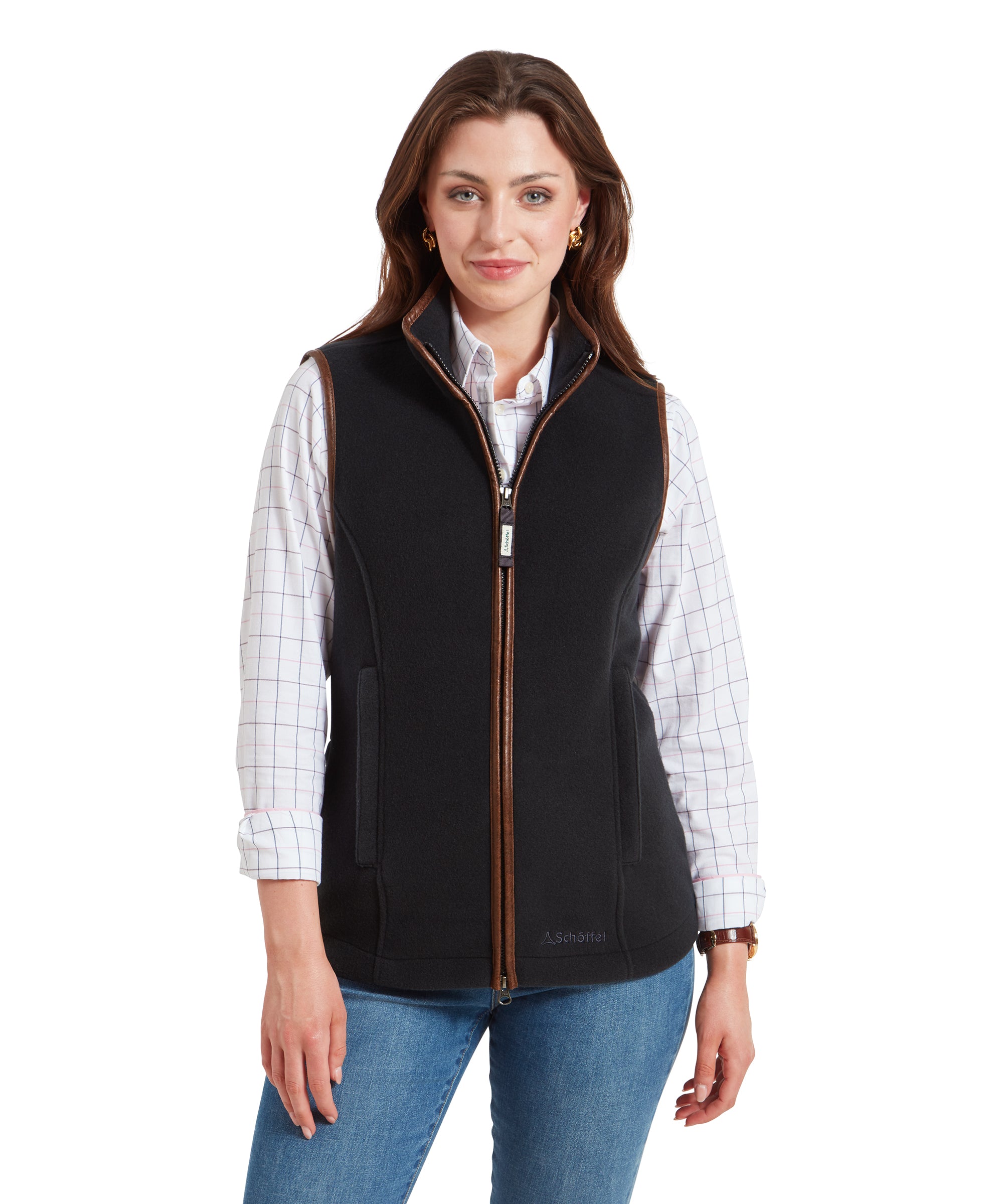 A woman wearing a Schöffel Lyndon Fleece Gilet for Women in Grey over a white checkered shirt. She is facing forward with a slight smile, hands relaxed by her sides. The gilet has brown piping along the zipper and armholes.