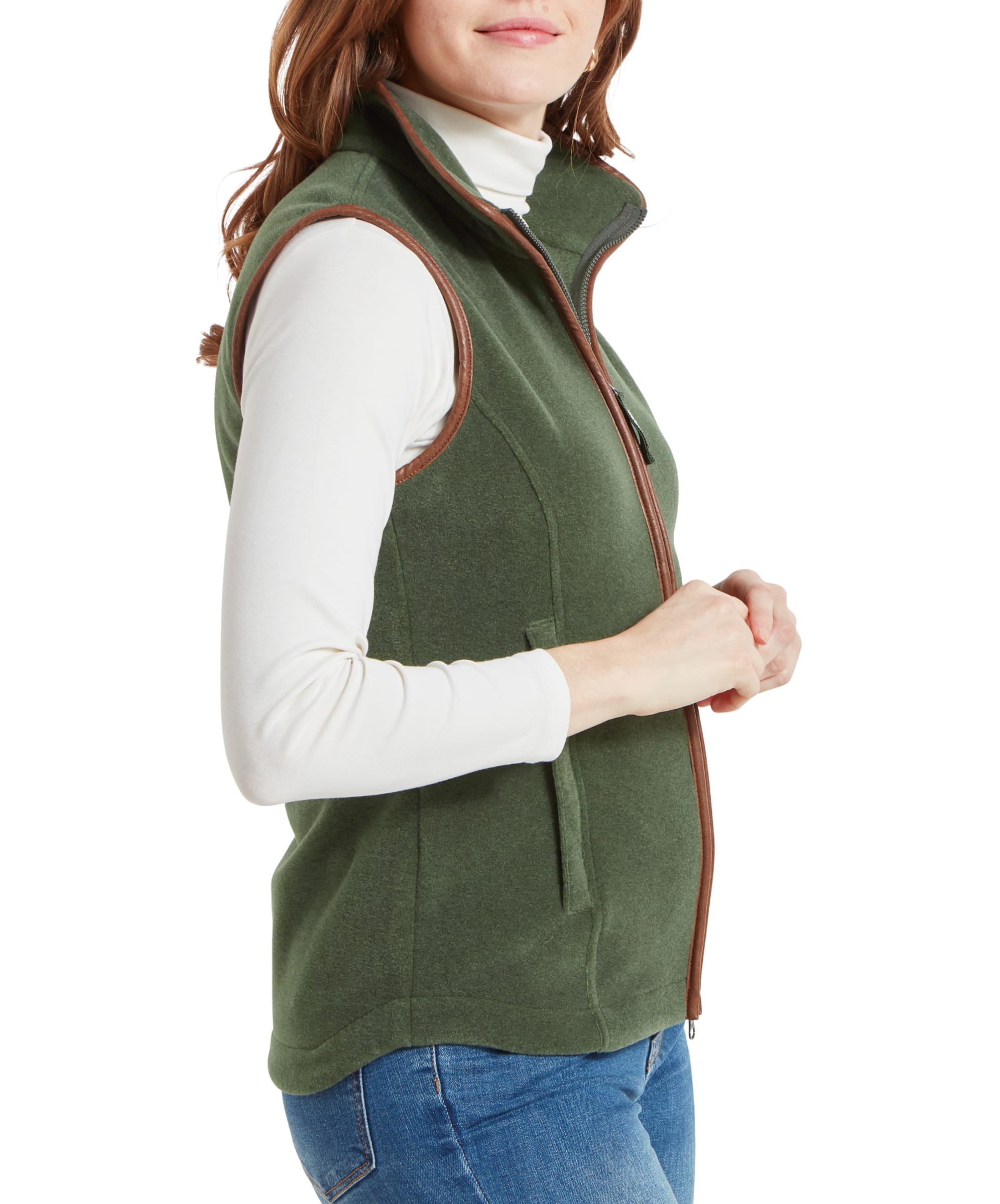 Side profile of a woman wearing a Schöffel Lyndon Fleece Gilet for Women in Green over a white turtleneck and blue jeans.