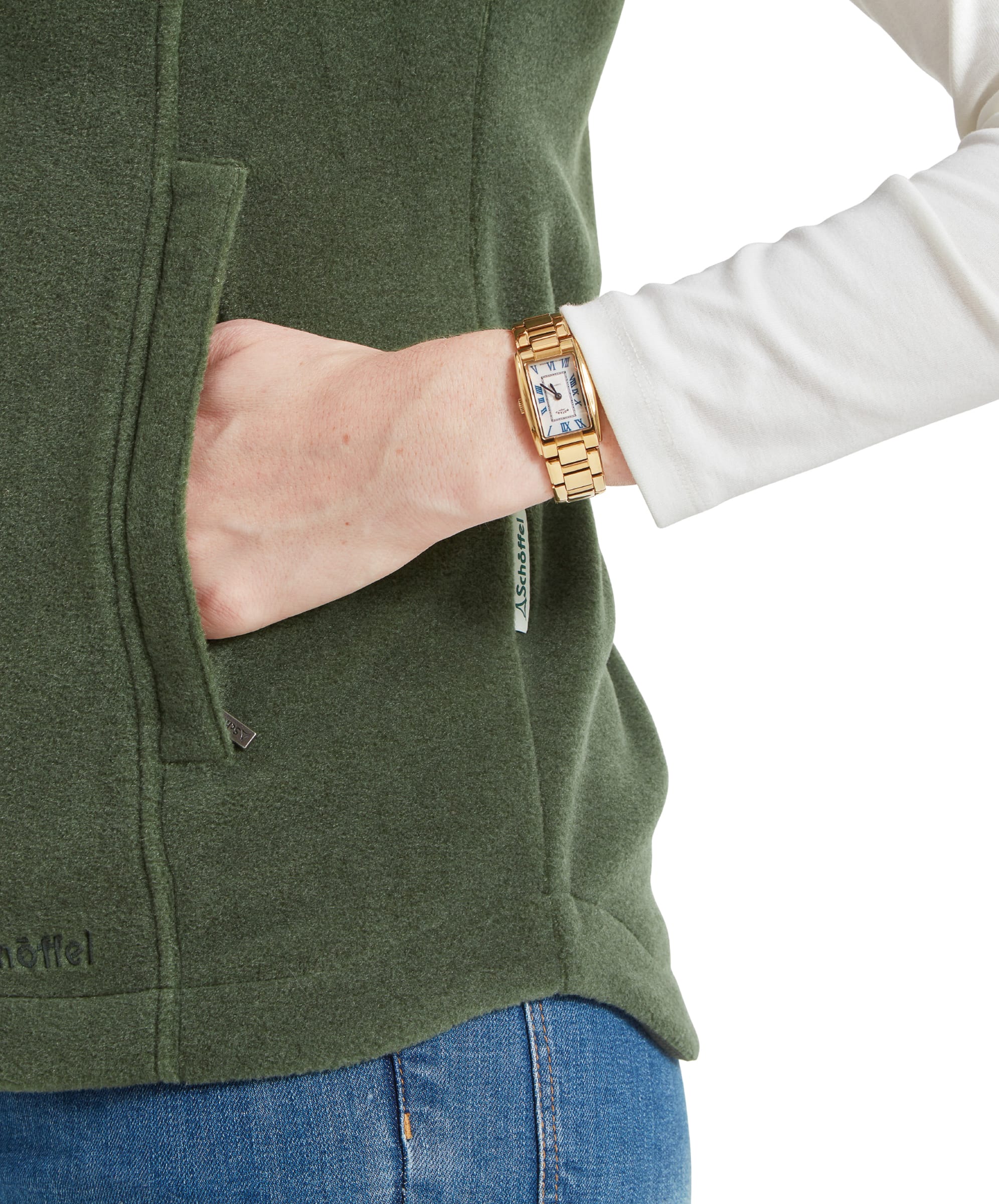 Close-up of a woman’s hand in the pocket of her Schöffel Lyndon Fleece Gilet for Women in Green, showing a gold watch on her wrist.