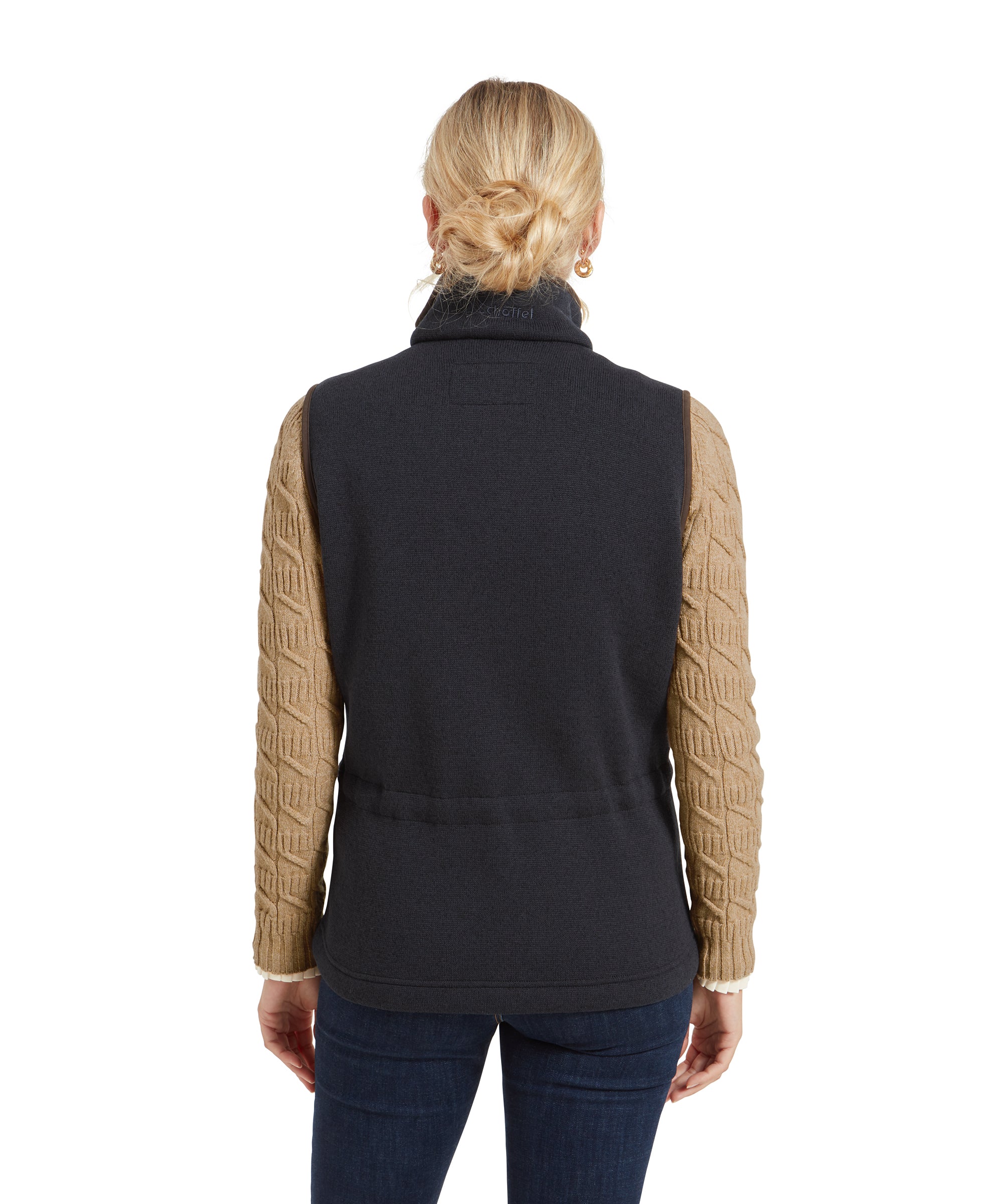 A rear view of the woman wearing the Schöffel Lyndon Hybrid Gilet for Women in Blue, showing the elasticated waist and the tan sweater sleeves.