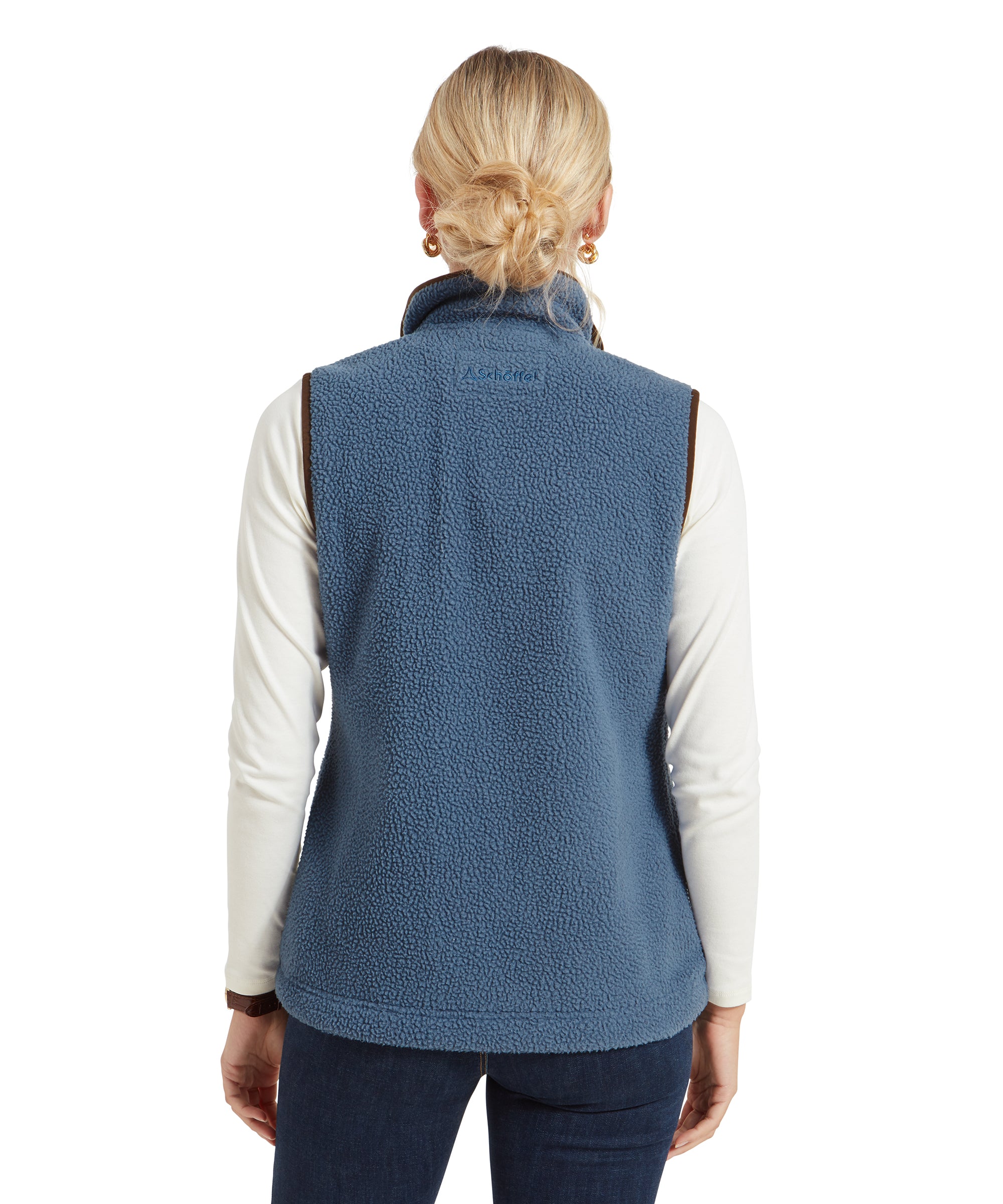 Back view of the woman wearing the Schöffel Lyndon Retro Fleece Gilet for Women in Navy, showing the back design, with her hair in a loose bun.