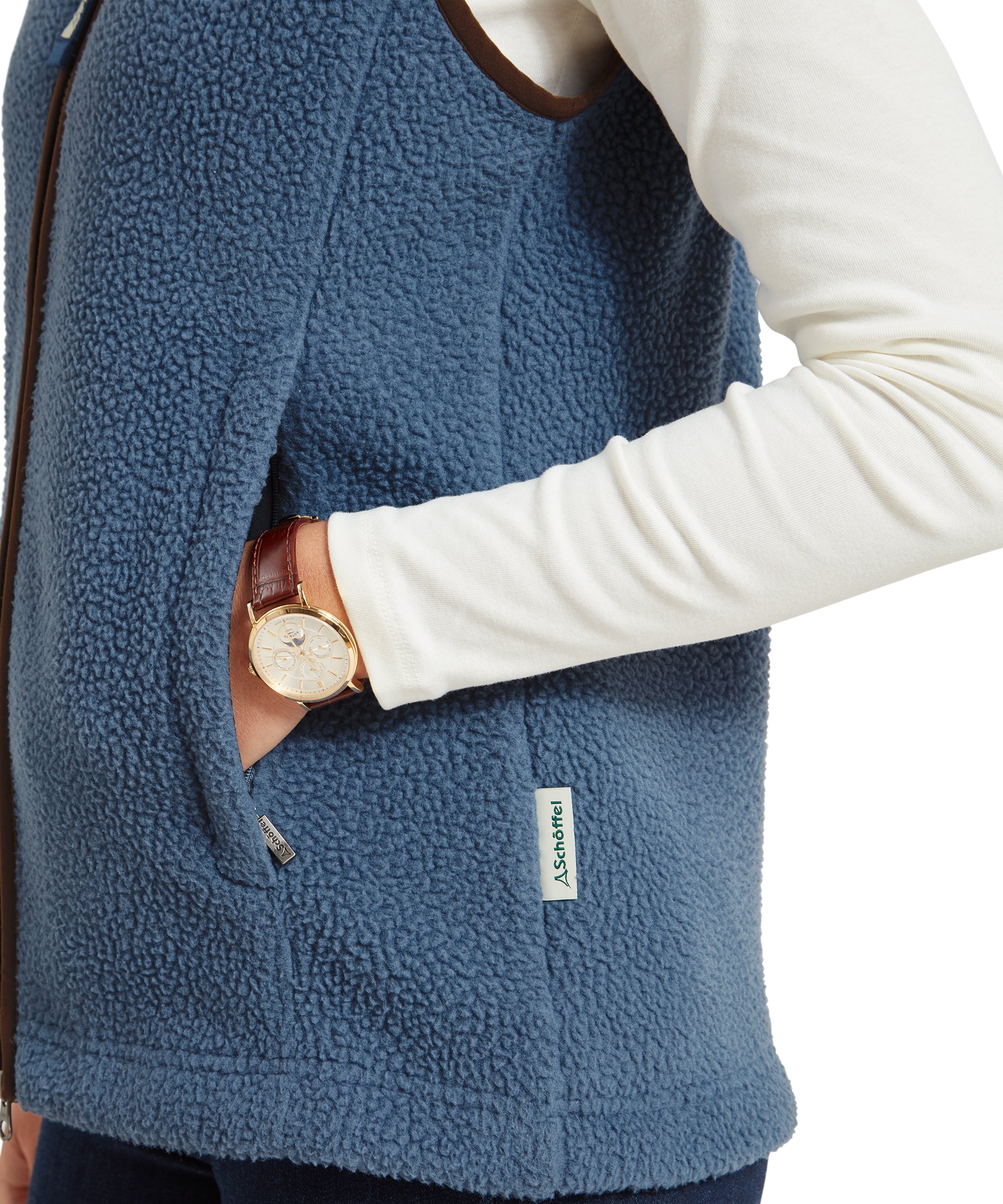 Close-up of the woman's midsection, highlighting the fleece texture and zipper details of the Schöffel Lyndon Retro Fleece Gilet for Women in Navy, with her hand in the pocket and a watch visible.