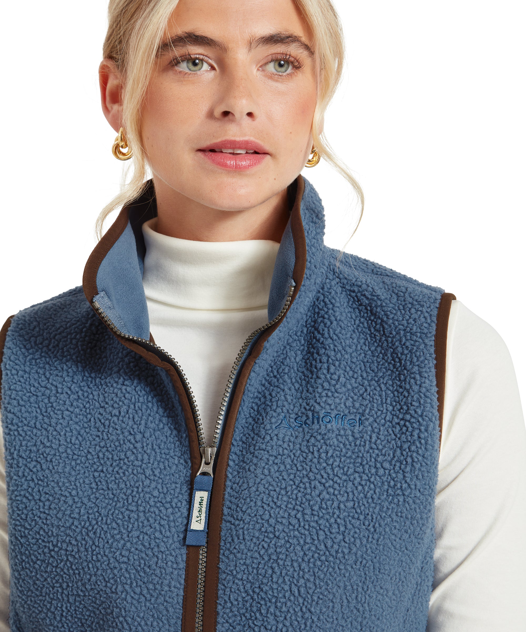 Close-up of the woman's upper body wearing the Schöffel Lyndon Retro Fleece Gilet for Women in Navy, showing the high collar, zipper, and brand logo, with her face partially in the frame.