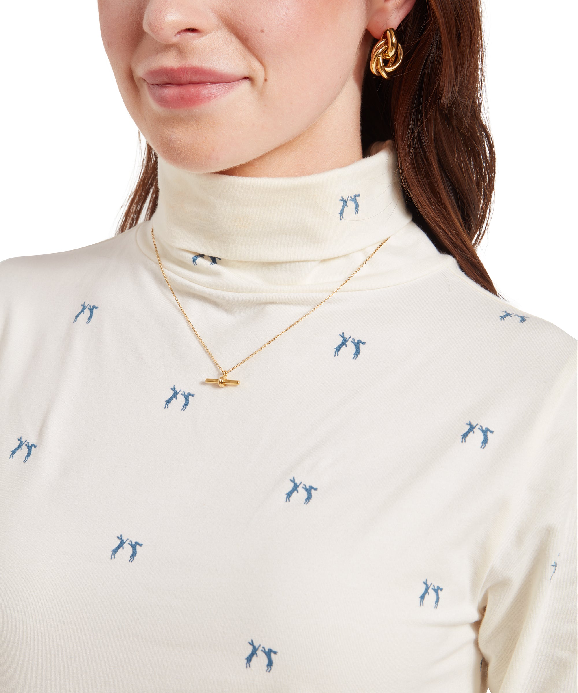 A close-up shot of the Schöffel Malham Top for Women in Blue, highlighting the small blue pattern, a gold necklace, and the woman's gold earrings.