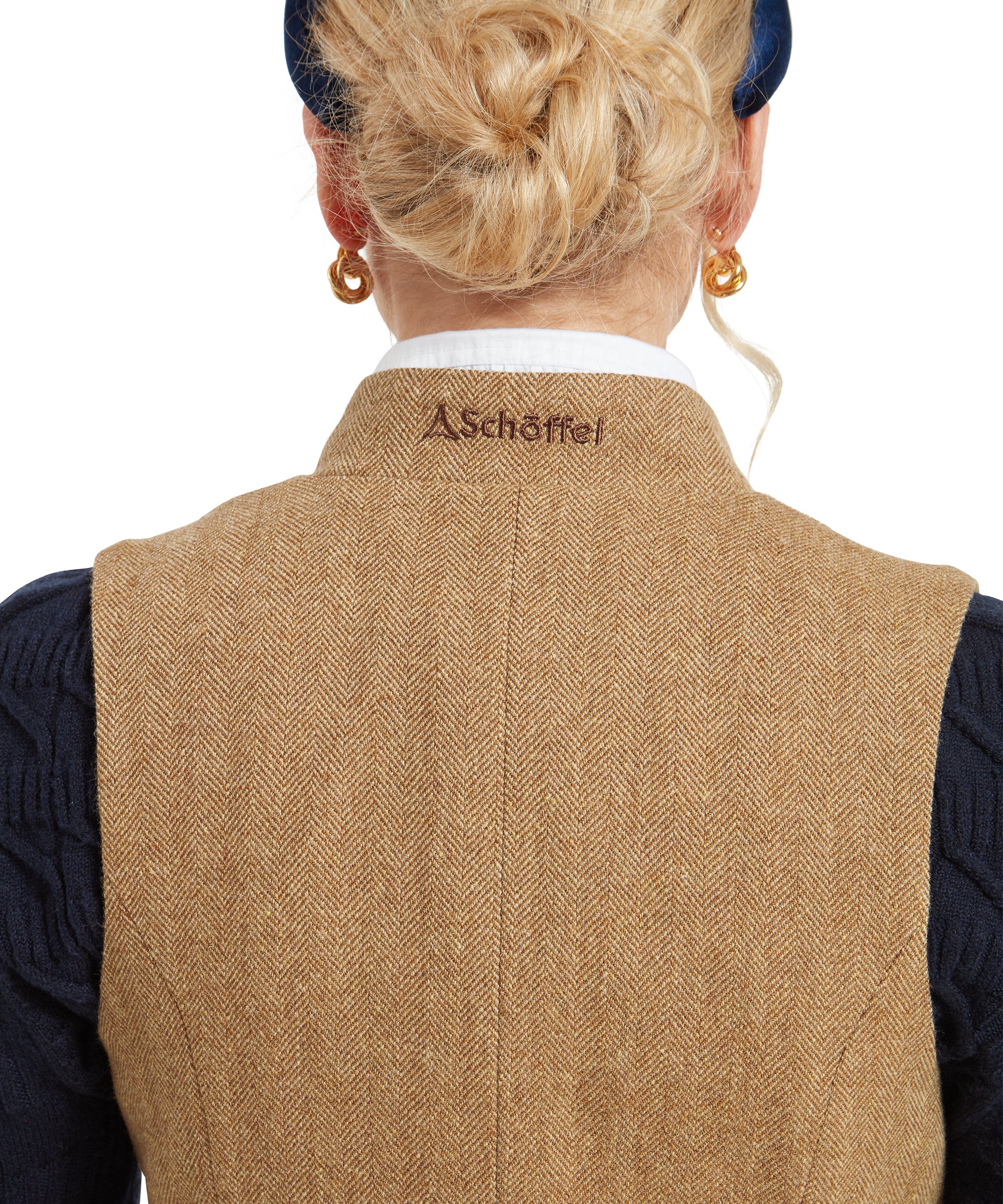 A close-up of the back of the Schöffel Millport Tweed Nehru Waistcoat for Womens in Light Brown, focusing on the embroidered logo on the collar.