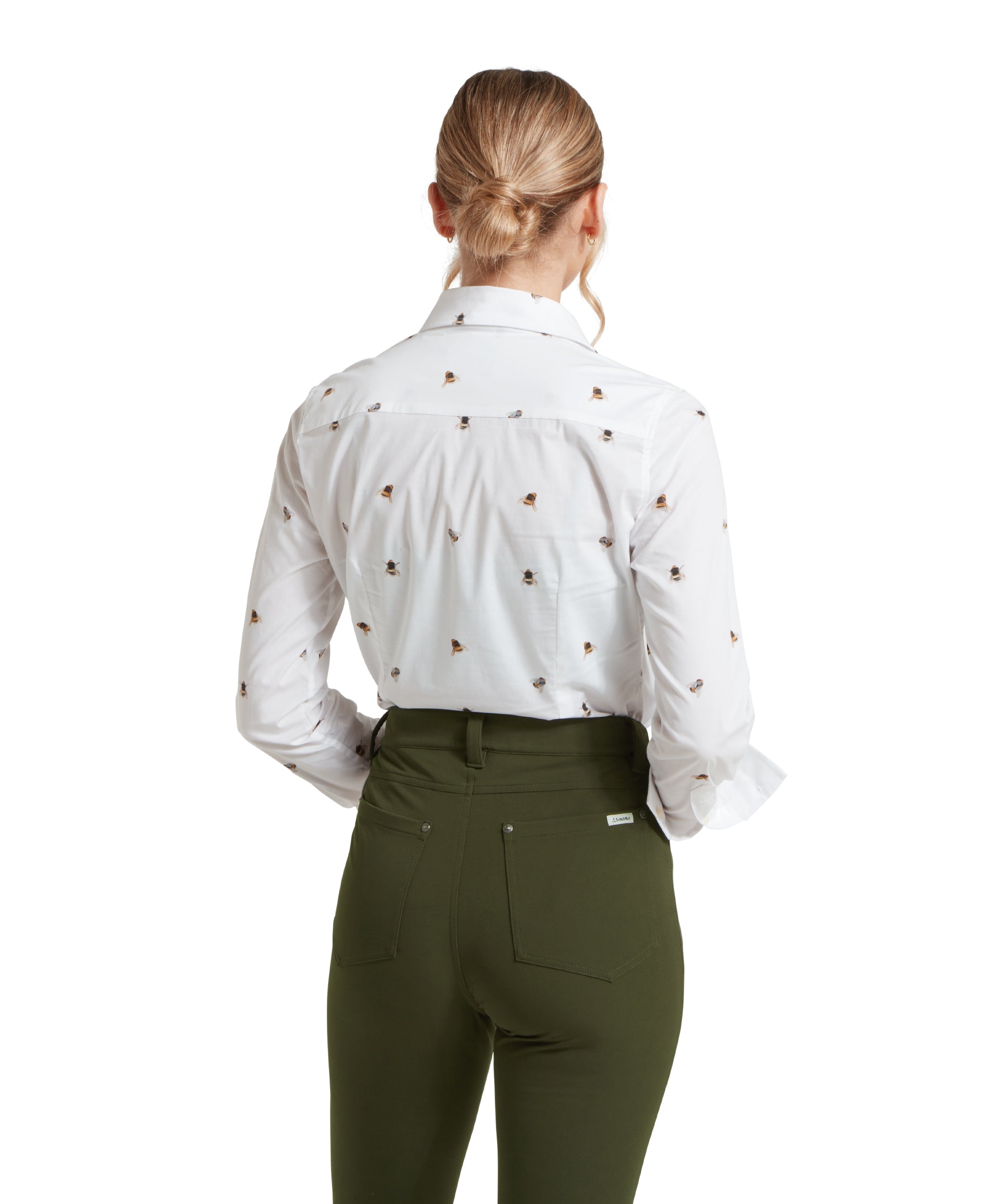 Back image of a female model wearing a white Schöffel shirt with a bee pattern, tucked into a pair of mid green trousers.