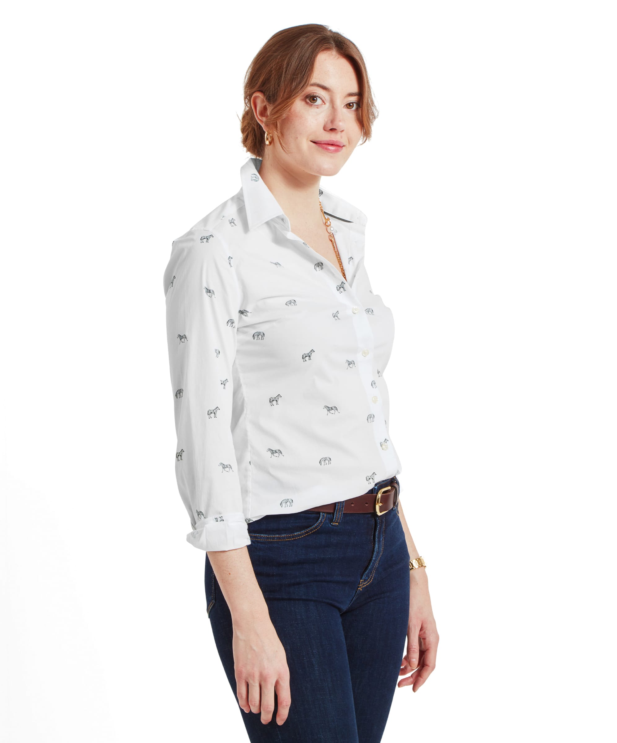 Side profile of the woman showing the fit of the Schöffel Norfolk Shirt for Womens in White Black with zebra prints, along with the dark blue jeans. She has her hair neatly tied back and is smiling slightly.