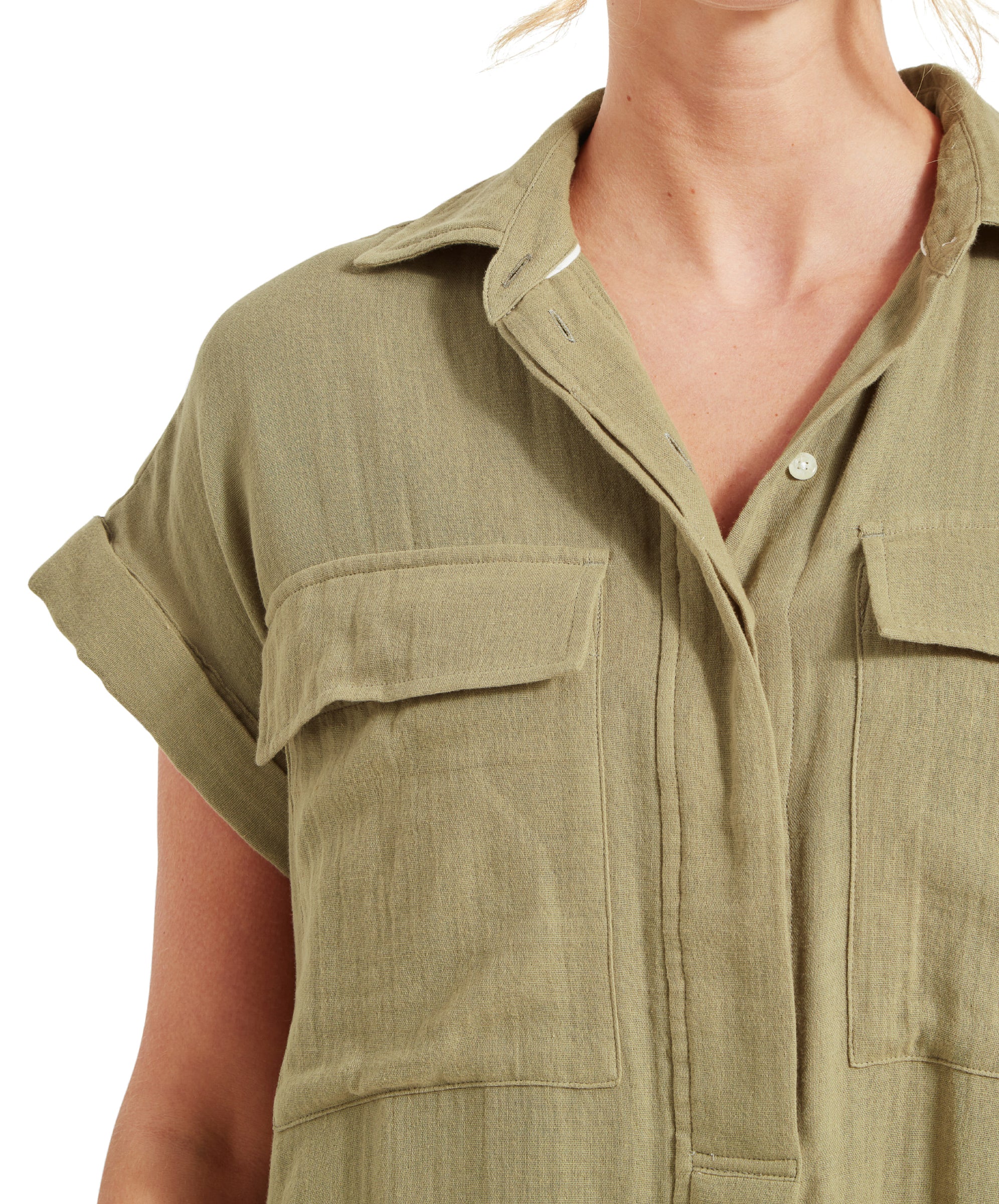 A close-up of the upper part of the Schöffel Olive Dress for Women in Green, showing the collar, front pockets, and button-up design. The dress has a relaxed fit and rolled-up sleeves.