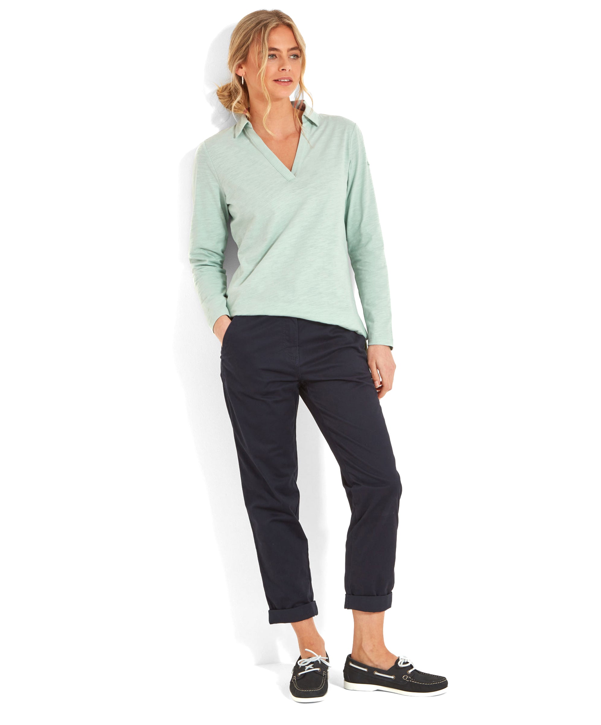 Full-body view of a woman wearing a Schöffel Pentle Bay Top for Women in Green and navy trousers, standing and smiling.