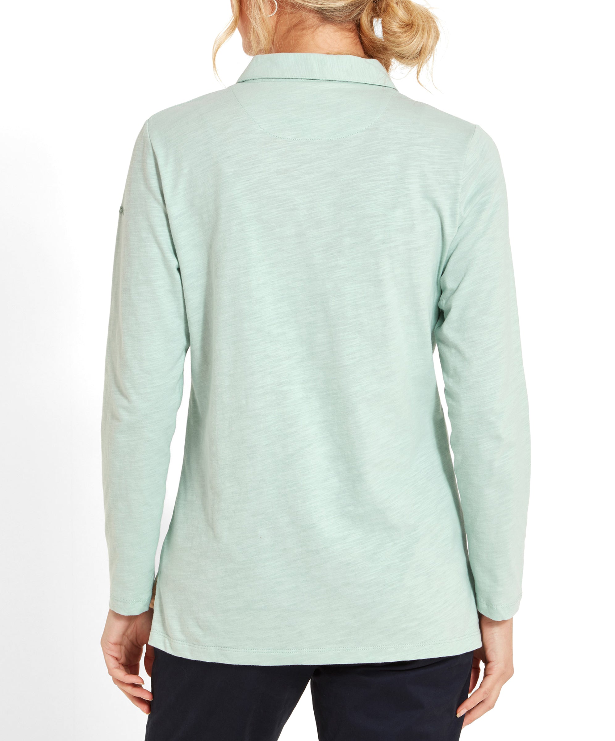 Back view of a woman wearing a Schöffel Pentle Bay Top for Women in Green and navy trousers.