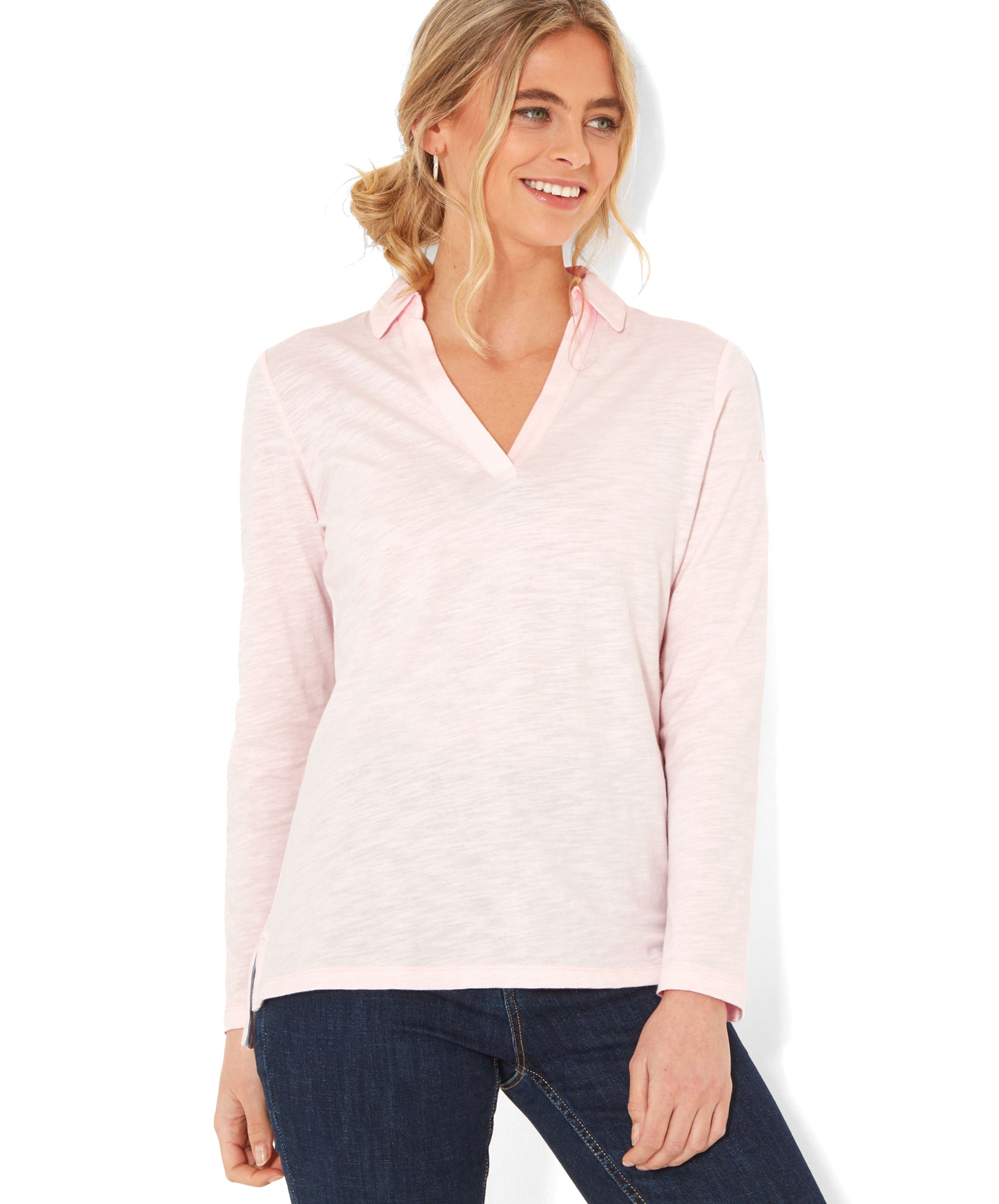 A woman wearing aSchöffel Pentle Bay Top for Women in Pink with a V-neck collar. She has her hair tied back in a loose bun and is smiling.