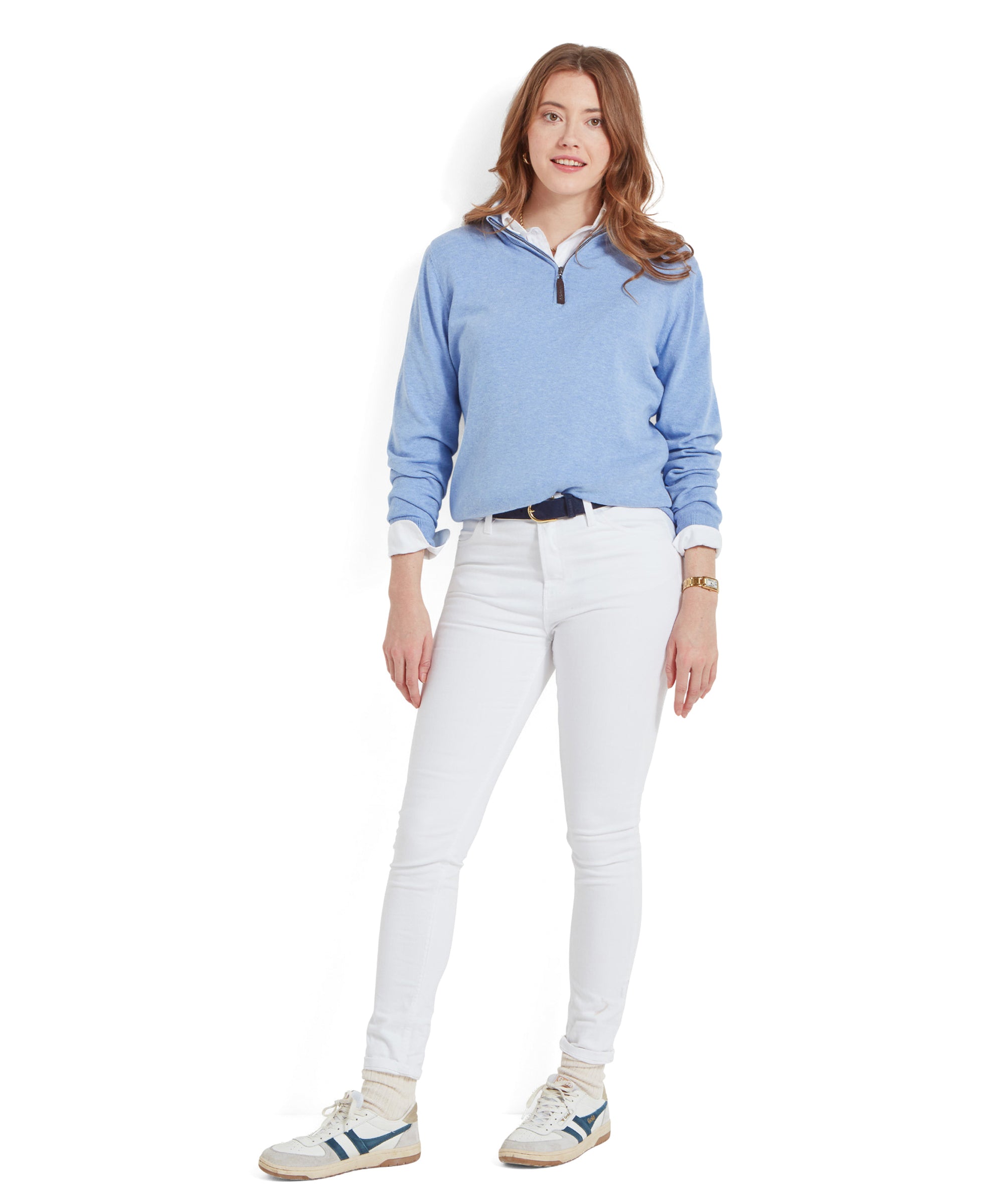 Full-body view of a woman in a Schöffel Polperro Pima Cotton 1/4 Zip for Women in Blue and white jeans, standing with hands in pockets.