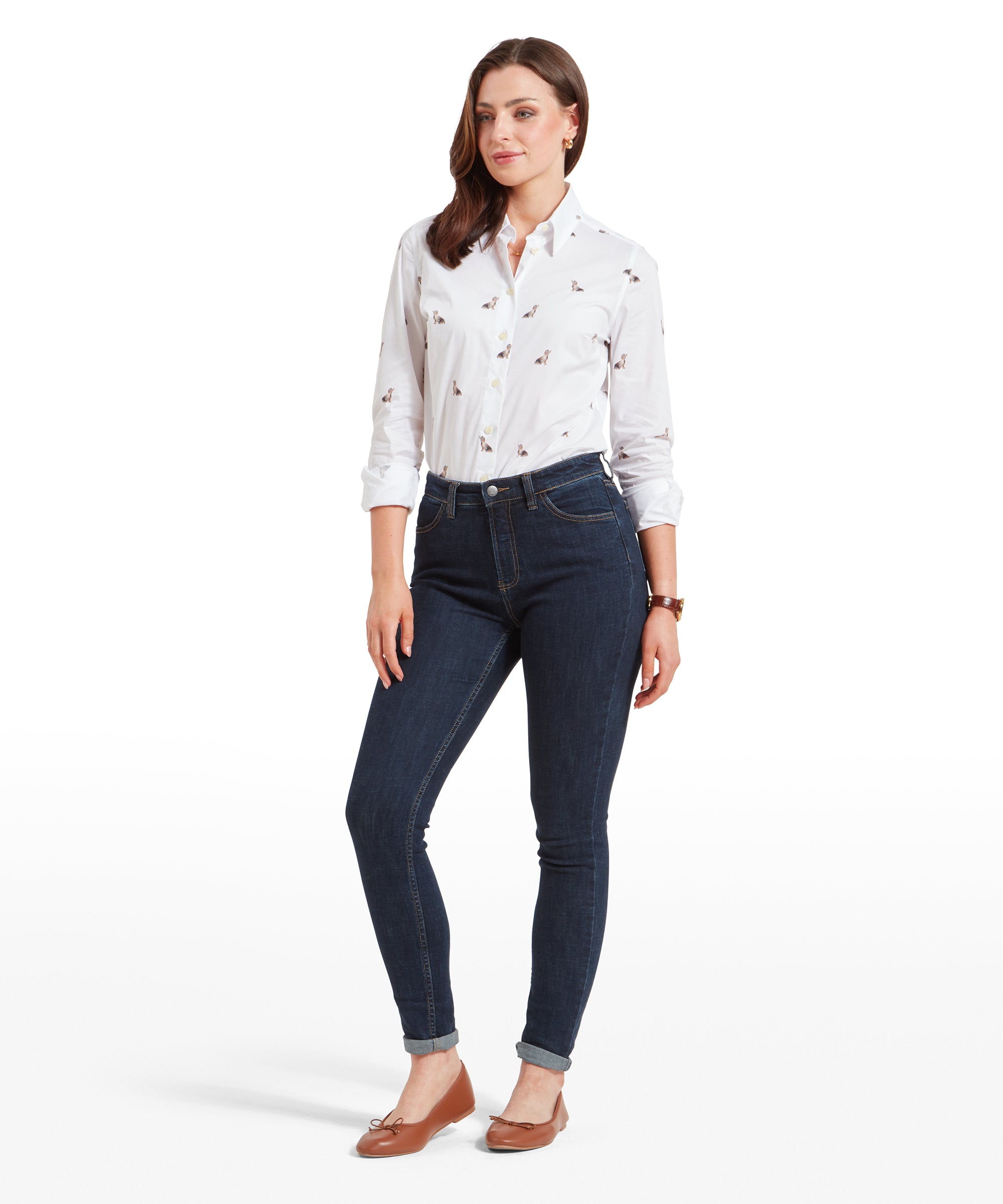 Full-body view of the woman dressed in the same outfit, standing confidently. The Schöffel Poppy Jean for Womens in Dark Blue are fitted and rolled at the ankles, and she completes the look with a white printed shirt and brown flats.