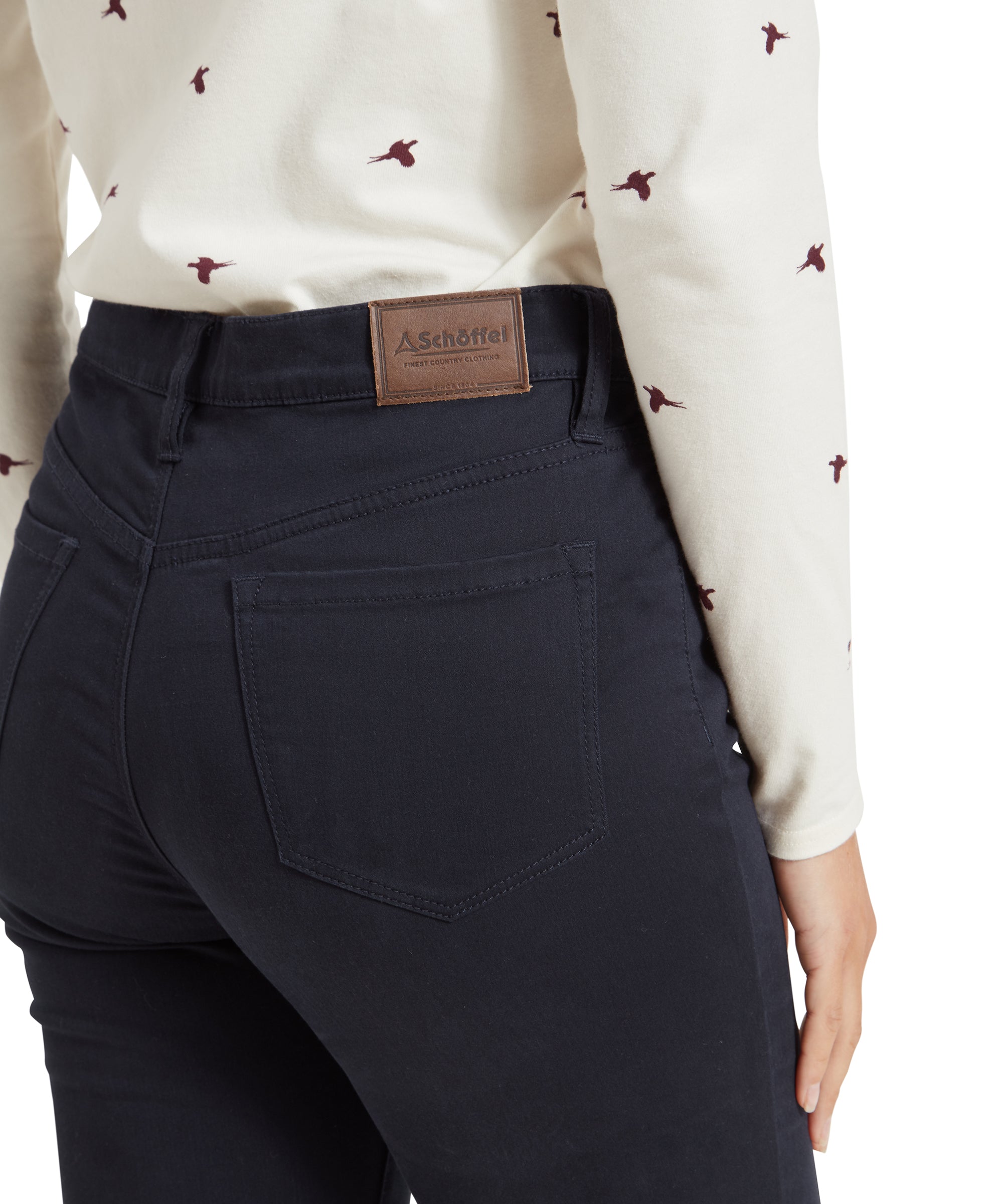 Close-up view of a back pocket on the Schöffel Poppy Jean for Womens in Navy, the jeans have a clean subtle design and matching stithcing. The back waistband features a leather look logo patch.