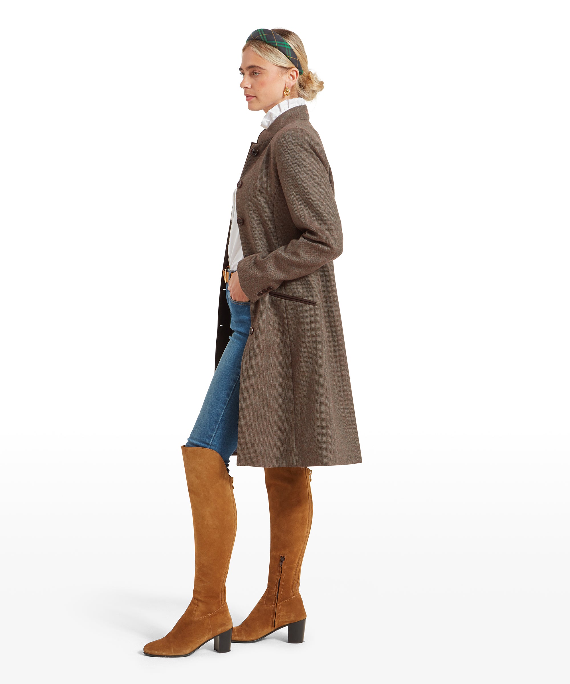 Side profile of a woman wearing a Schöffel Portree Tweed Jacket for Women in Green with tan knee-high boots, looking slightly to her left.