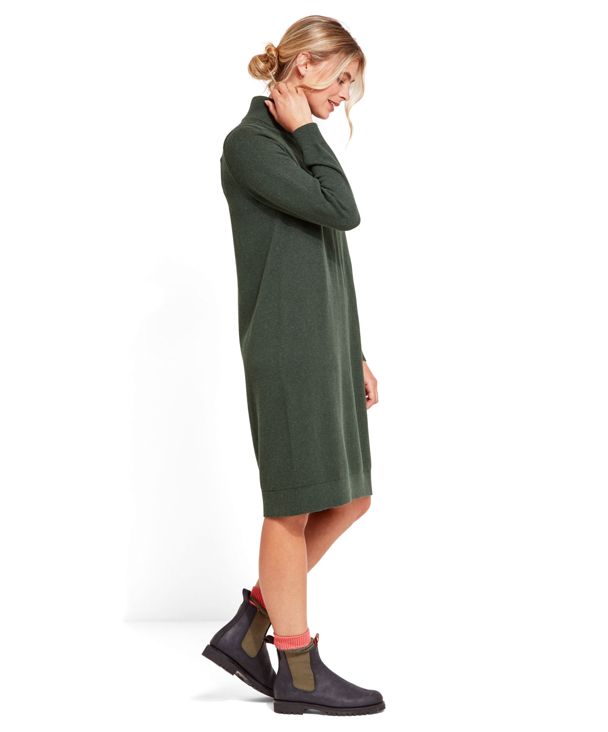 A side view of the model in the Schöffel Primrose Dress for Women in Green, emphasizing the relaxed fit and knee-length hem.