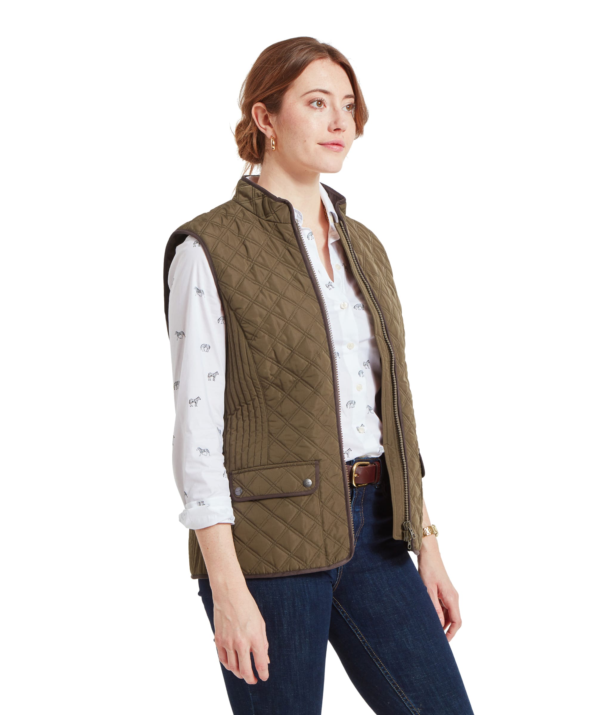 Side profile of a woman wearing a Schöffel Quilt Gilet for Women in Green over a white shirt, standing with a neutral expression.