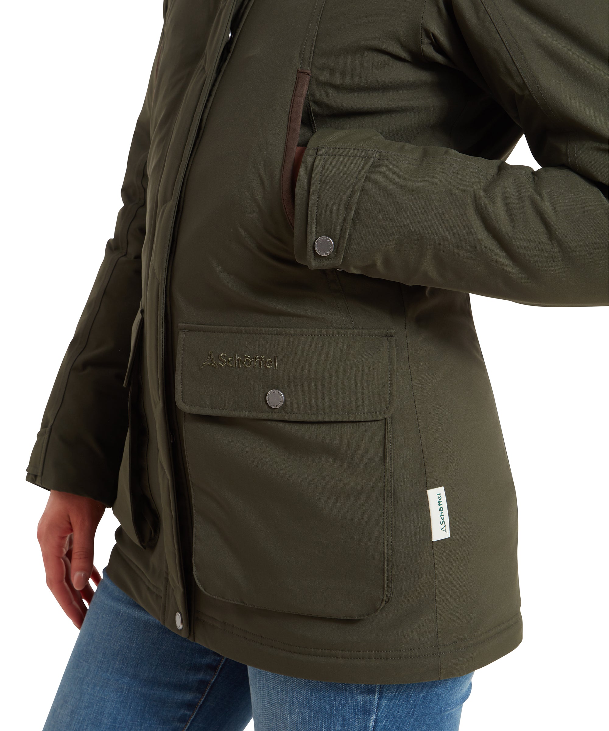 A close-up of the pocket area of the Schöffel Rockingham II Coat for Women in Green, showing the Schöffel logo and pocket flaps.