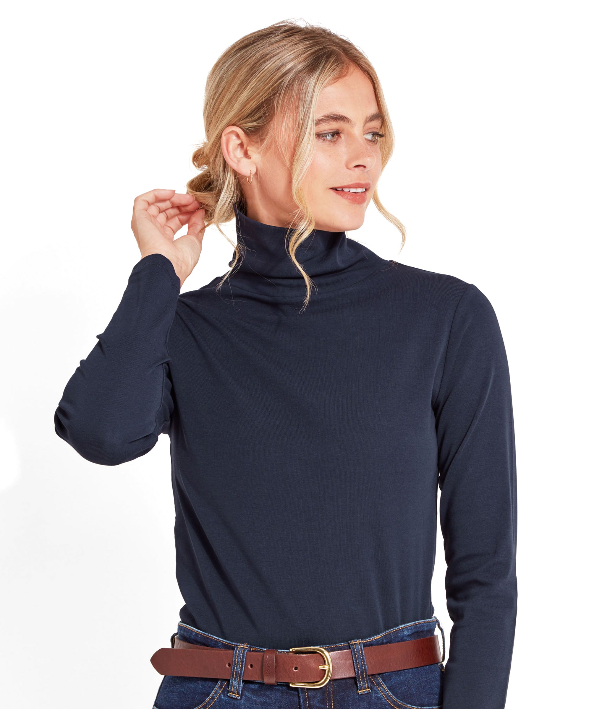 A woman is posing in a Schöffel Rosedale Roll Neck for Women in Navy with her hair tied back, looking to the side.