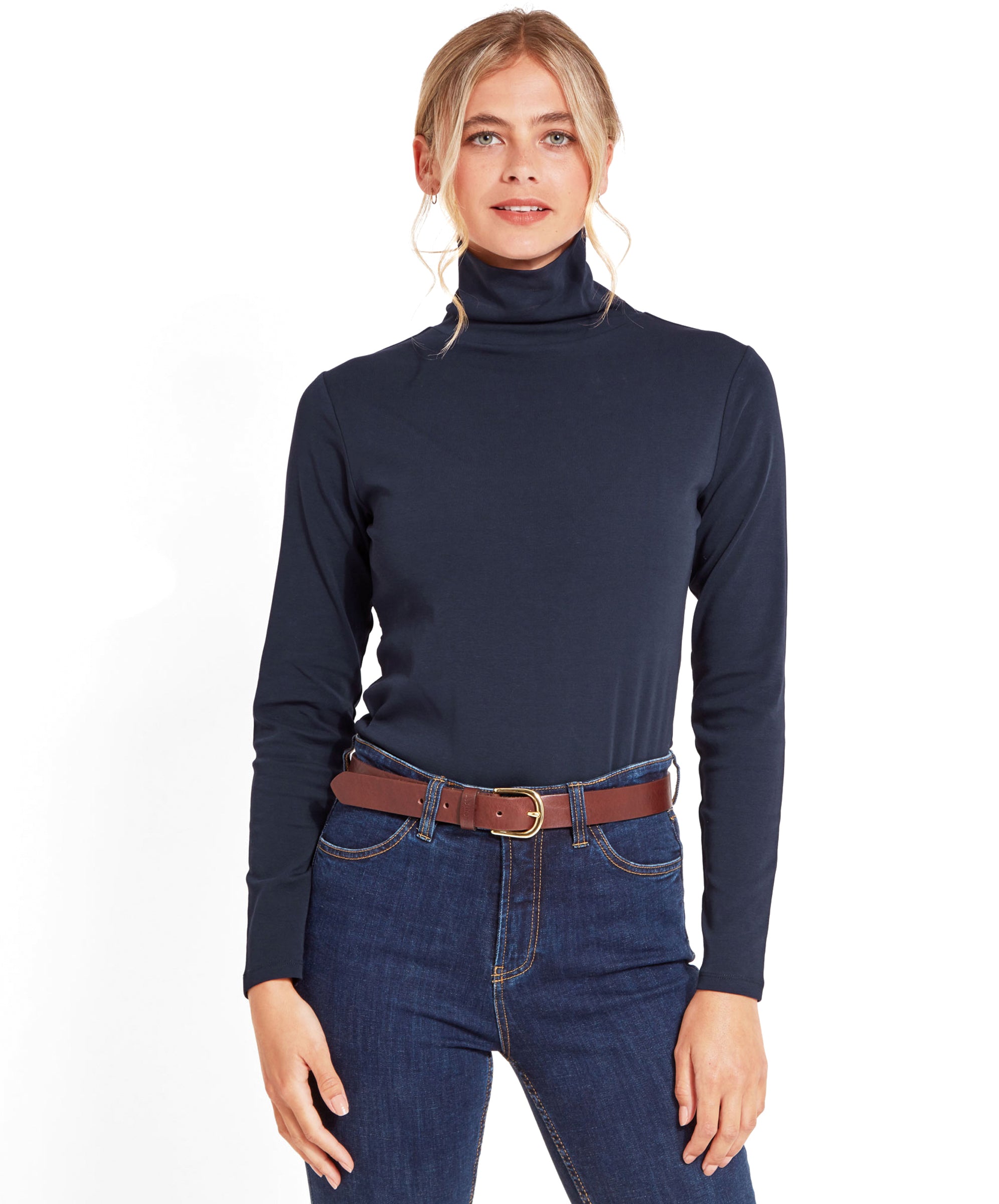 Front view of the woman standing with her hands by her sides, wearing the Schöffel Rosedale Roll Neck for Women in Navy tucked into dark blue jeans.