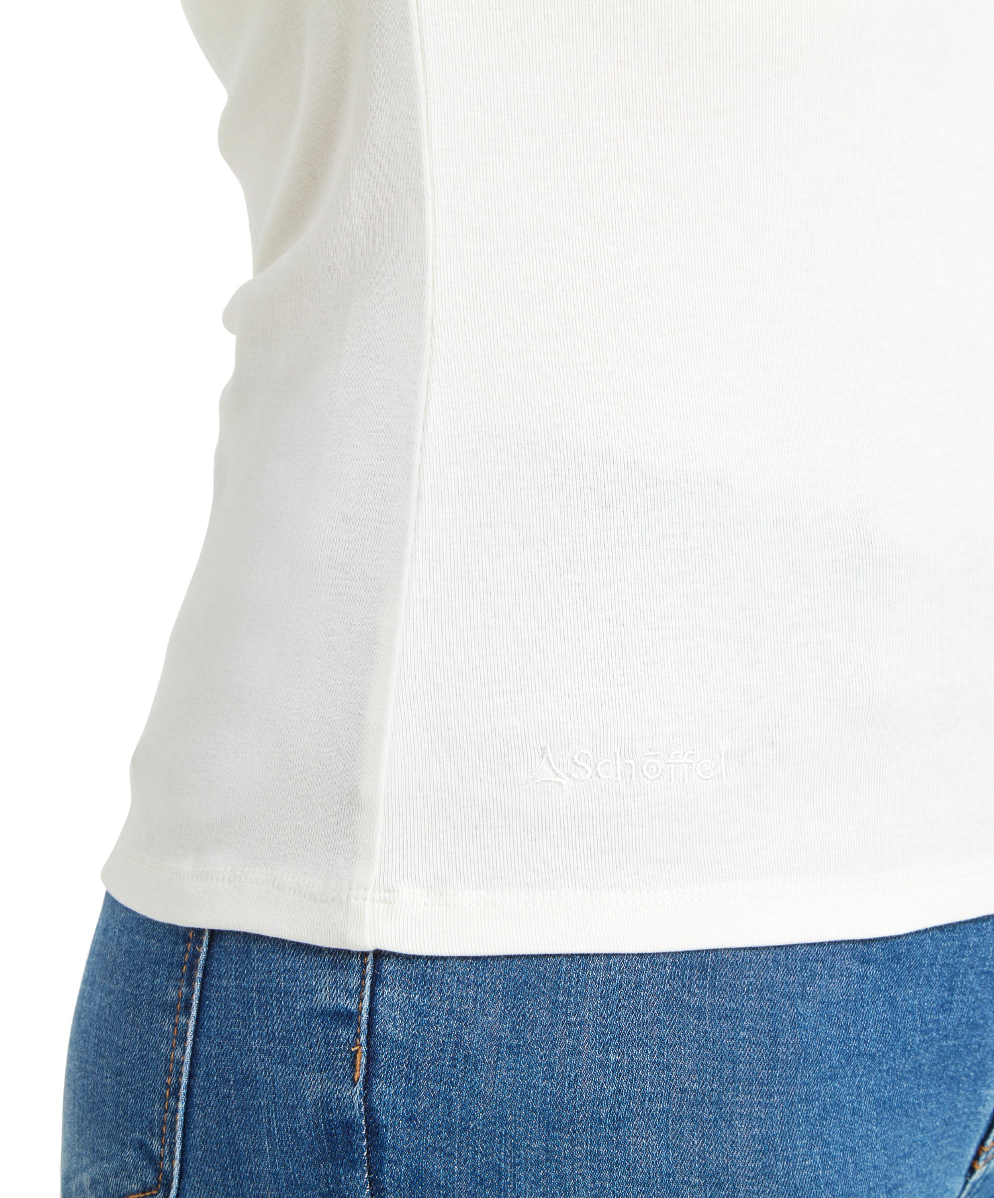 A close-up of the lower side of the Schöffel Rosedale Roll Neck for Women in White, highlighting the subtle embroidered brand logo near the hem.