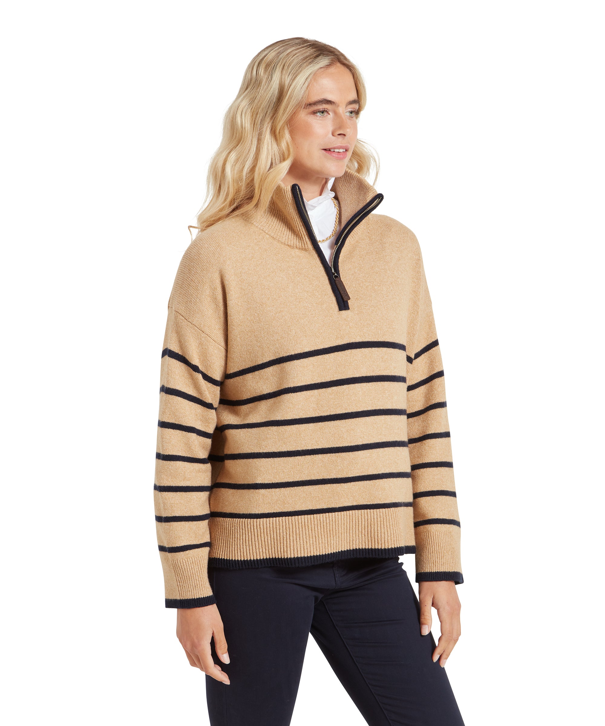 Side profile of the woman in the Schöffel Sandsend 1/4 Jumper for Women in Beige, showcasing the relaxed fit and the horizontal stripes. She wears navy trousers, looking to the side with a gentle smile.