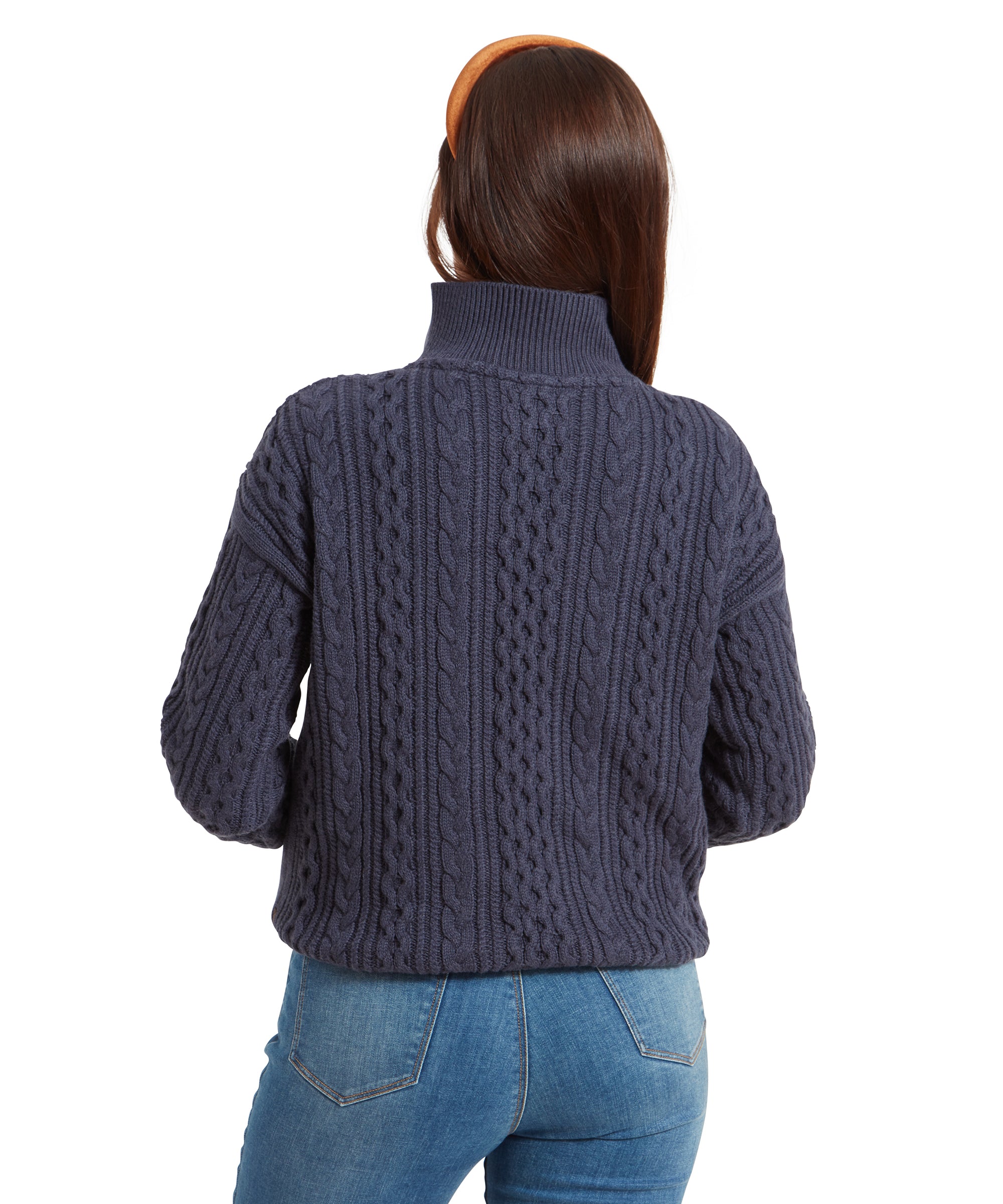 The back view of the woman wearing the Schöffel Settle 1/4 Zip for Women in Navy. The image highlights the detailed cable-knit pattern running along the back of the sweater, and the high collar is folded down slightly.